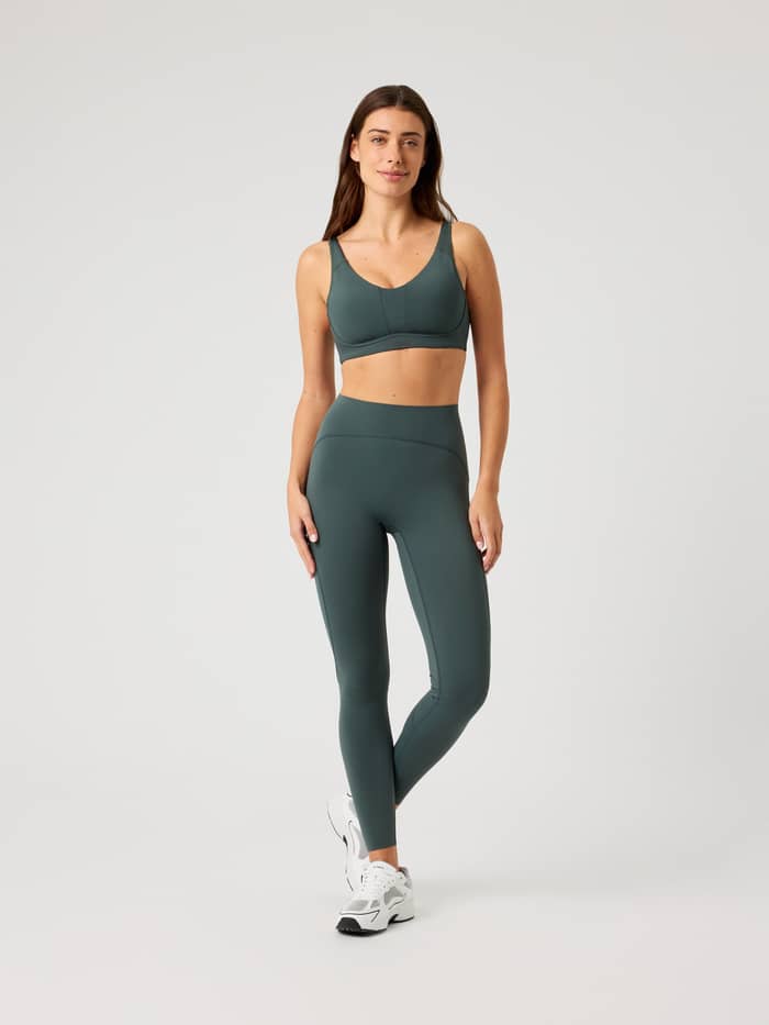 Borg Reform Sports Bra i Urban Chic (Grön) med medelhögt stöd och matchande träningsleggings sedda i helfigur framifrån. - Image 3