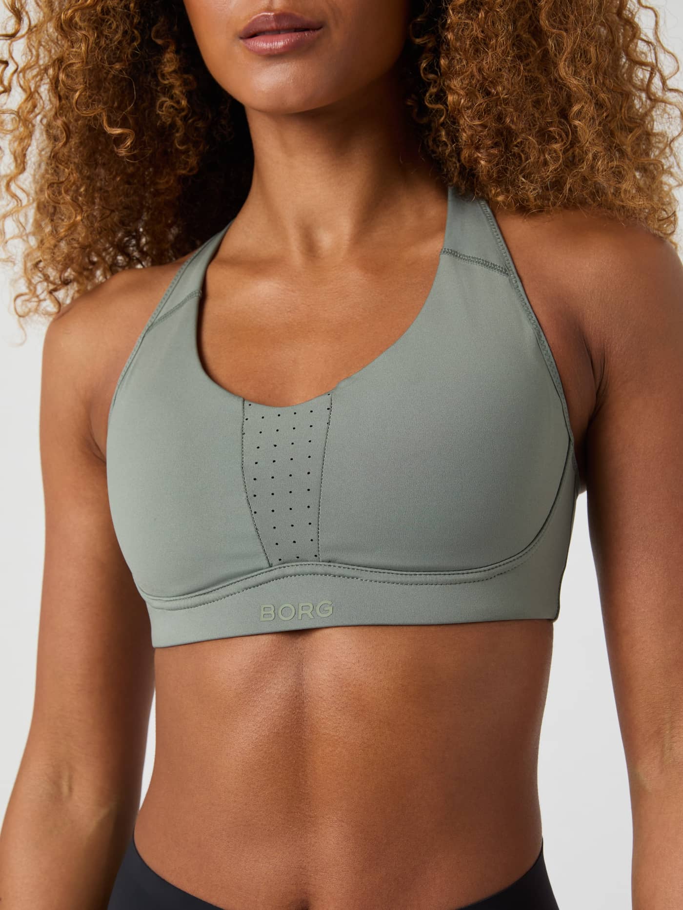 Close-up front view of a model wearing the Borg Reform Sports Bra in Agave Green. - Image 3