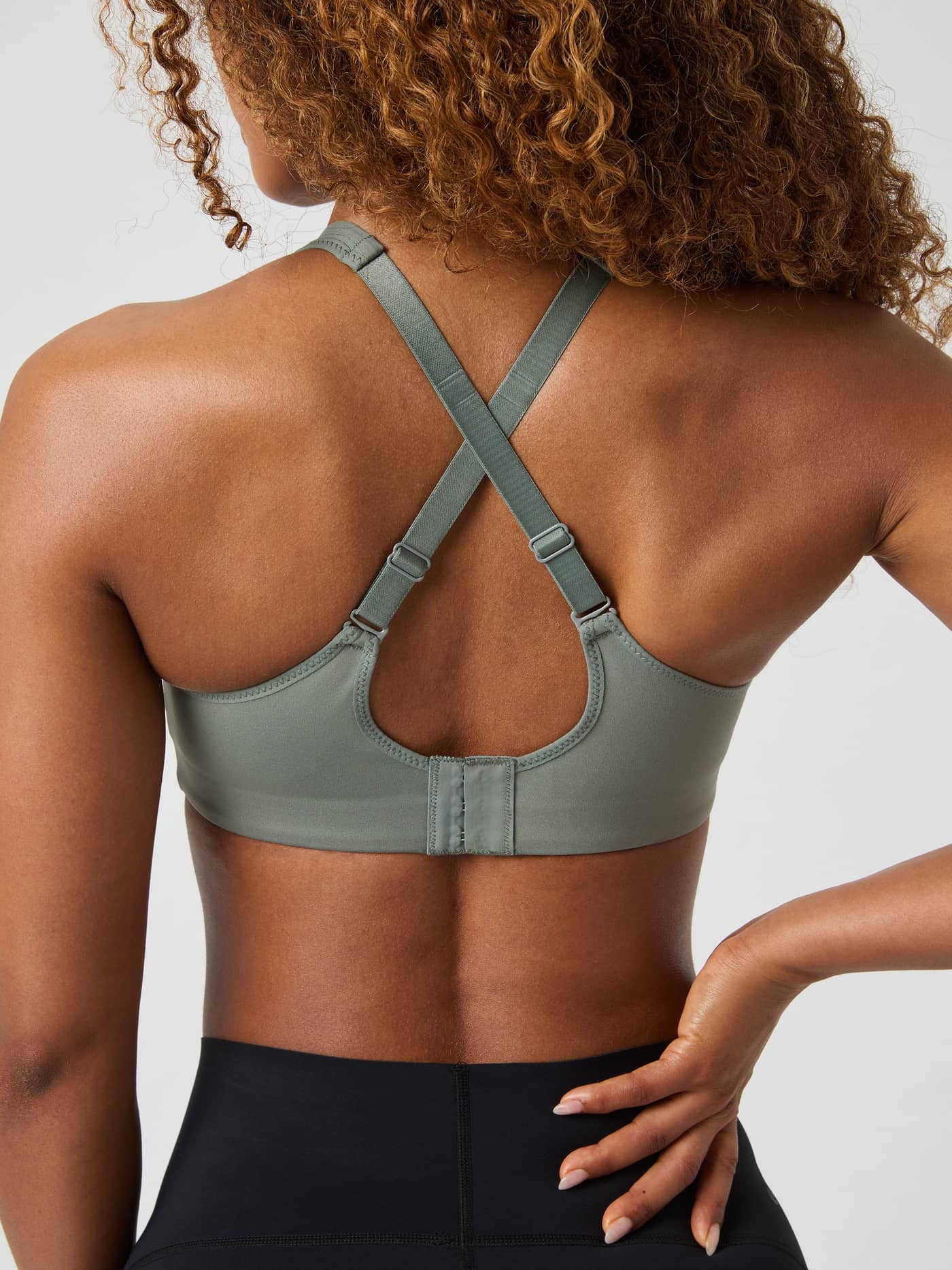 Back view of a model wearing the Borg Reform Sports Bra in Agave Green, showing the adjustable criss-cross straps. - Image 4