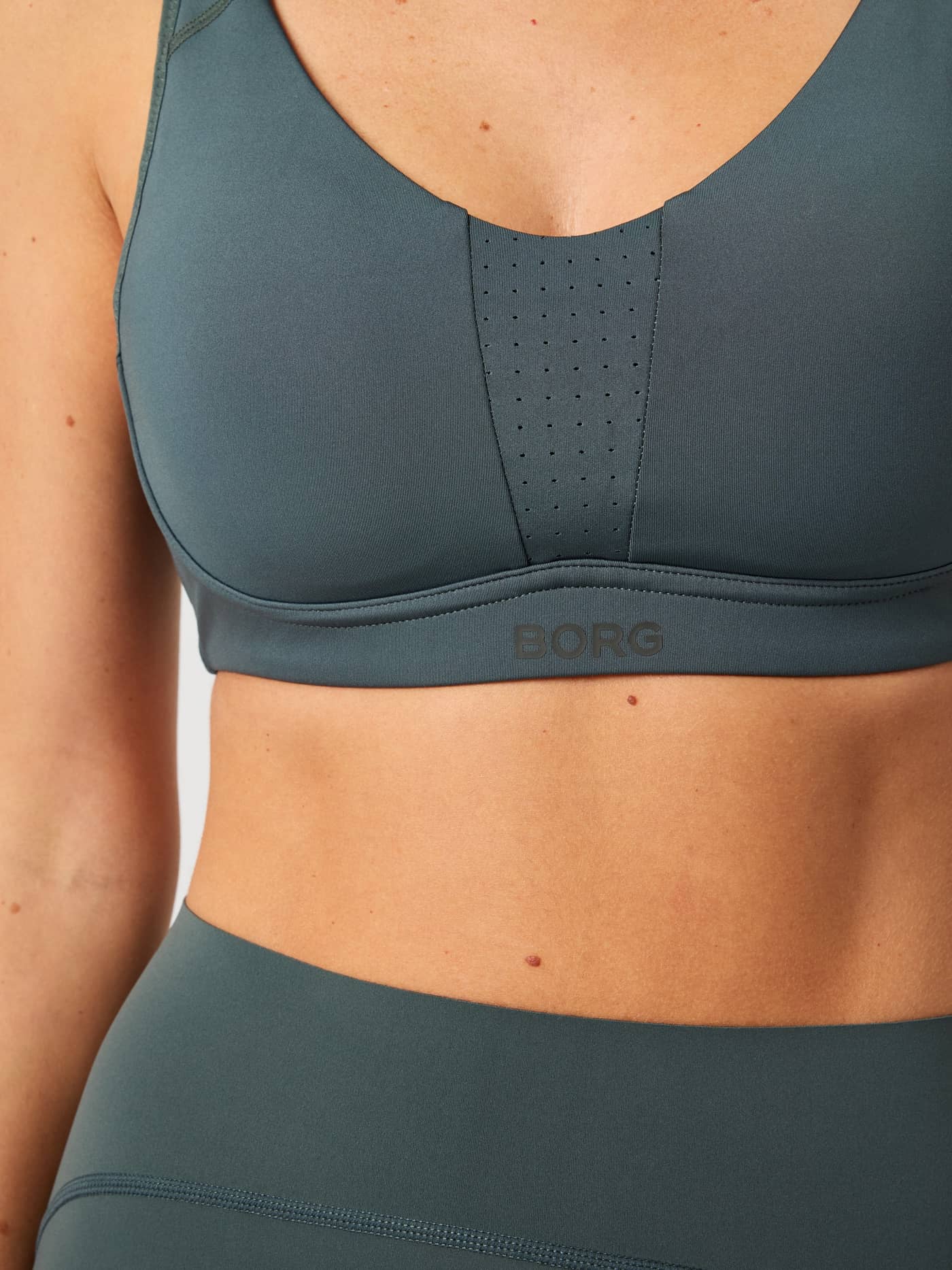 Vue de face du Borg Reform Sports Bra Urban Chic (Vert) aux détails découpés au laser et logo foncé pour le training. - Image 4