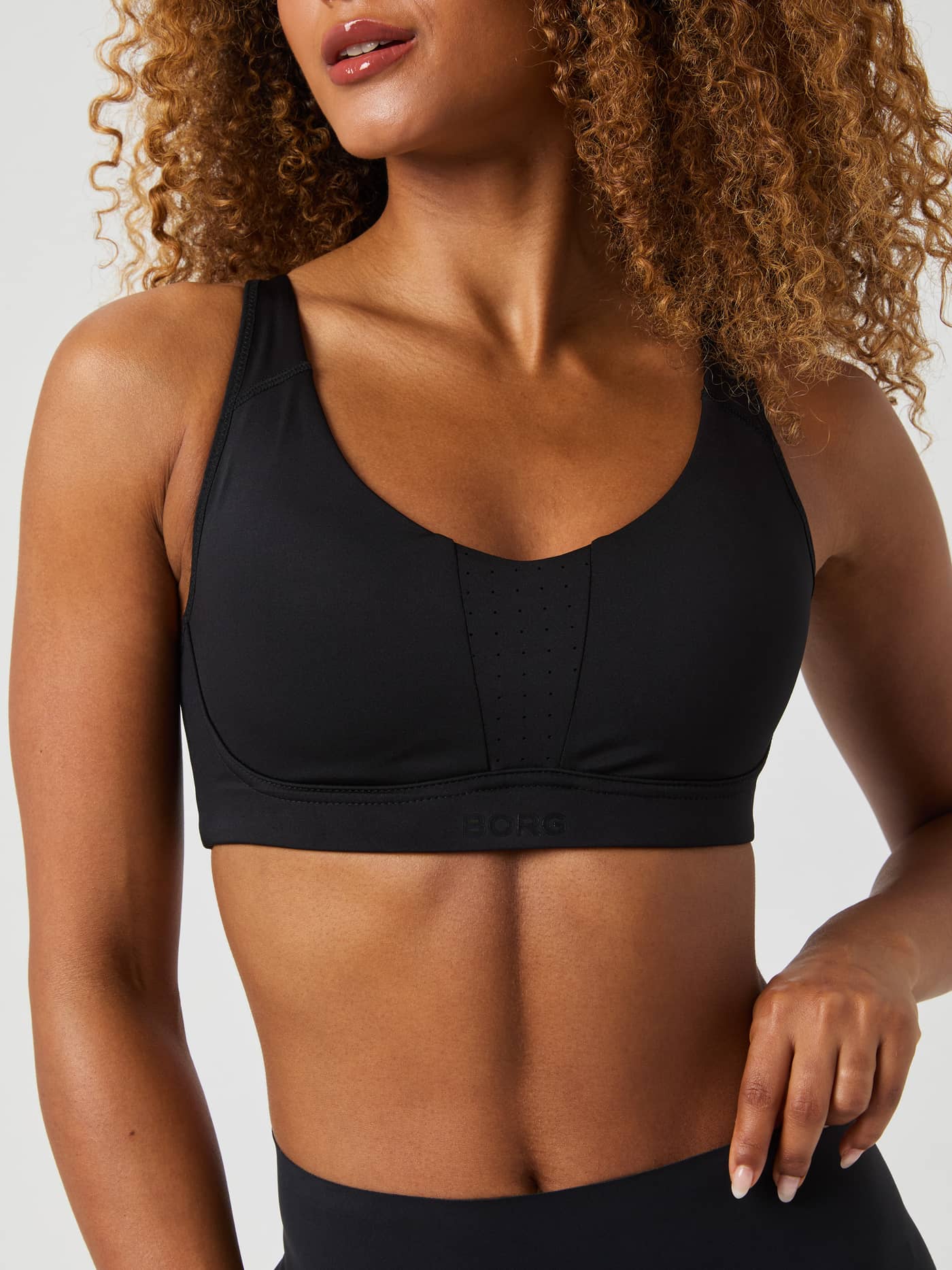 Close-up front view of a model wearing the Borg Reform Sports Bra in black. - Image 2