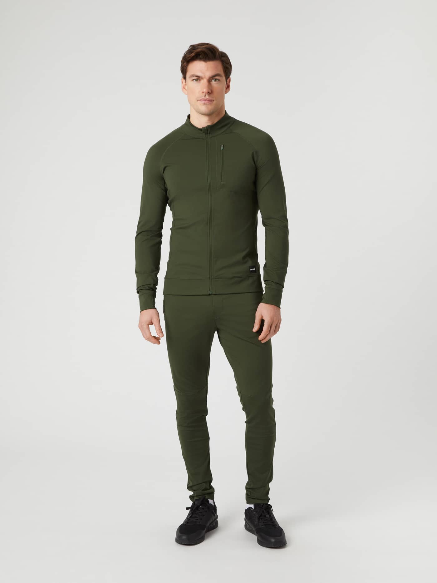 Full-body front view of a man wearing the Borg Training Midlayer Jacket in Duffel Bag (Green) for a functional stretch fit. - Image 3