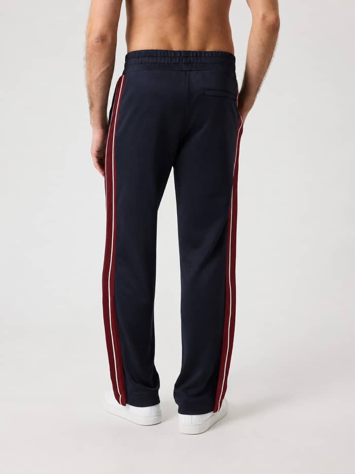 Back view of the Ace Retro Track Pants in Night sky (Navy) featuring contrasting side panels and a zippered back pocket.