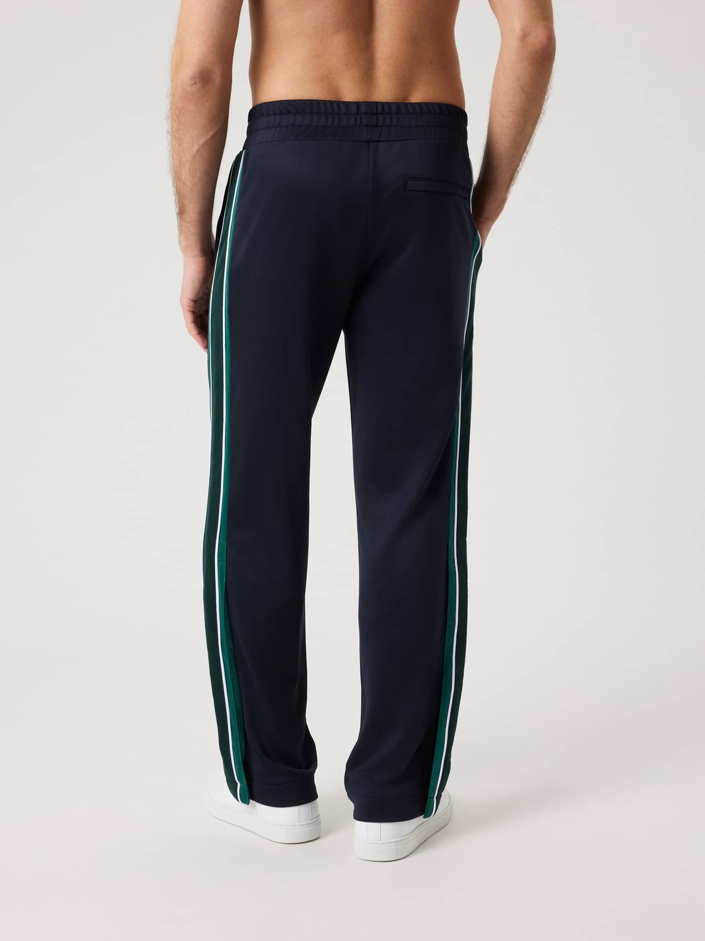 Ace Retro Track Pants i Night sky (Marineblå) set bagfra på en mand med grønne retro-sidepaneler til stil og tennis. - Image 2