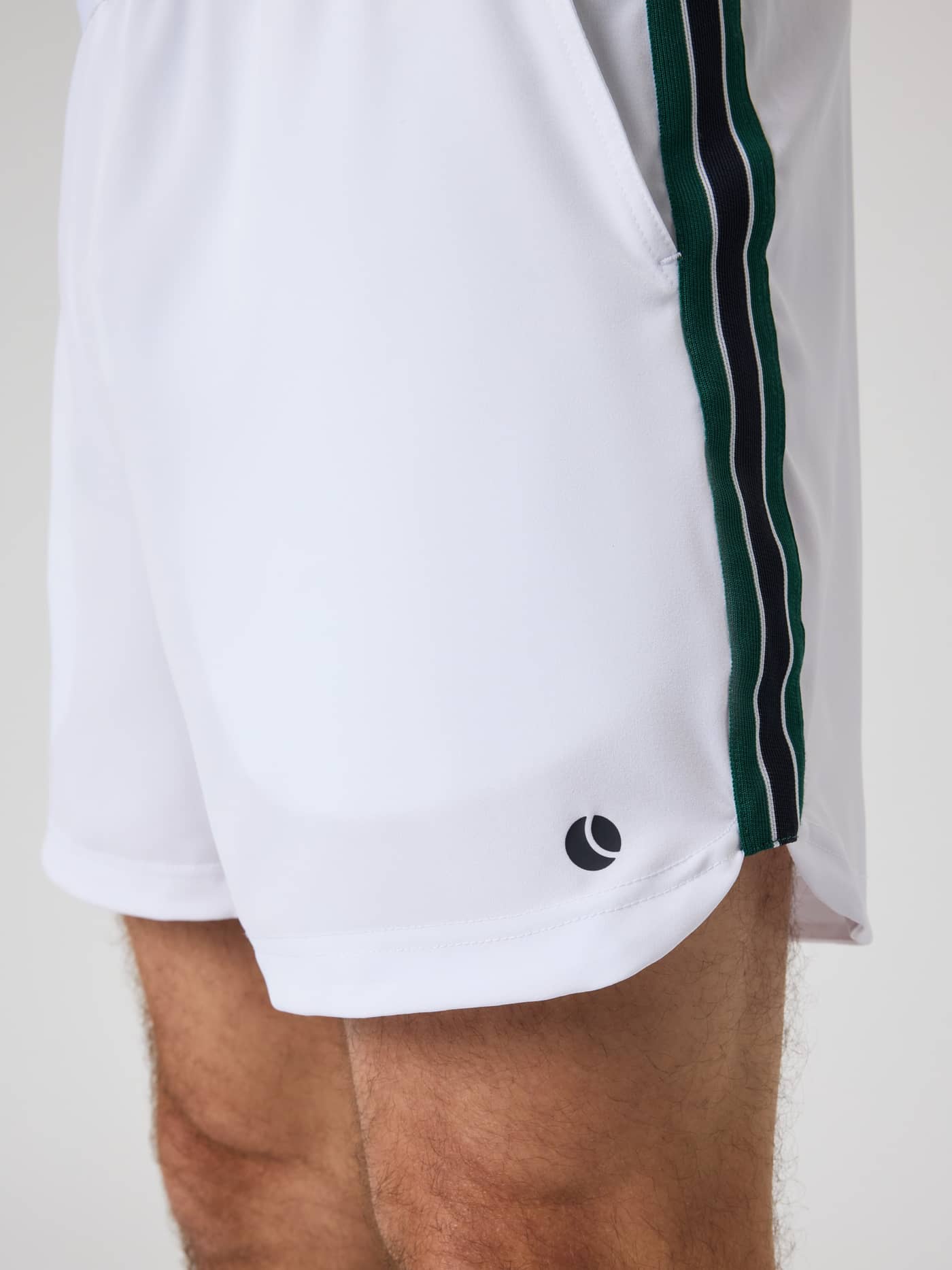 Close-up of the Ace Retro Shorts 6 Inch in Brilliant White (White) featuring retro side stripes and a tennis ball logo. - Image 4