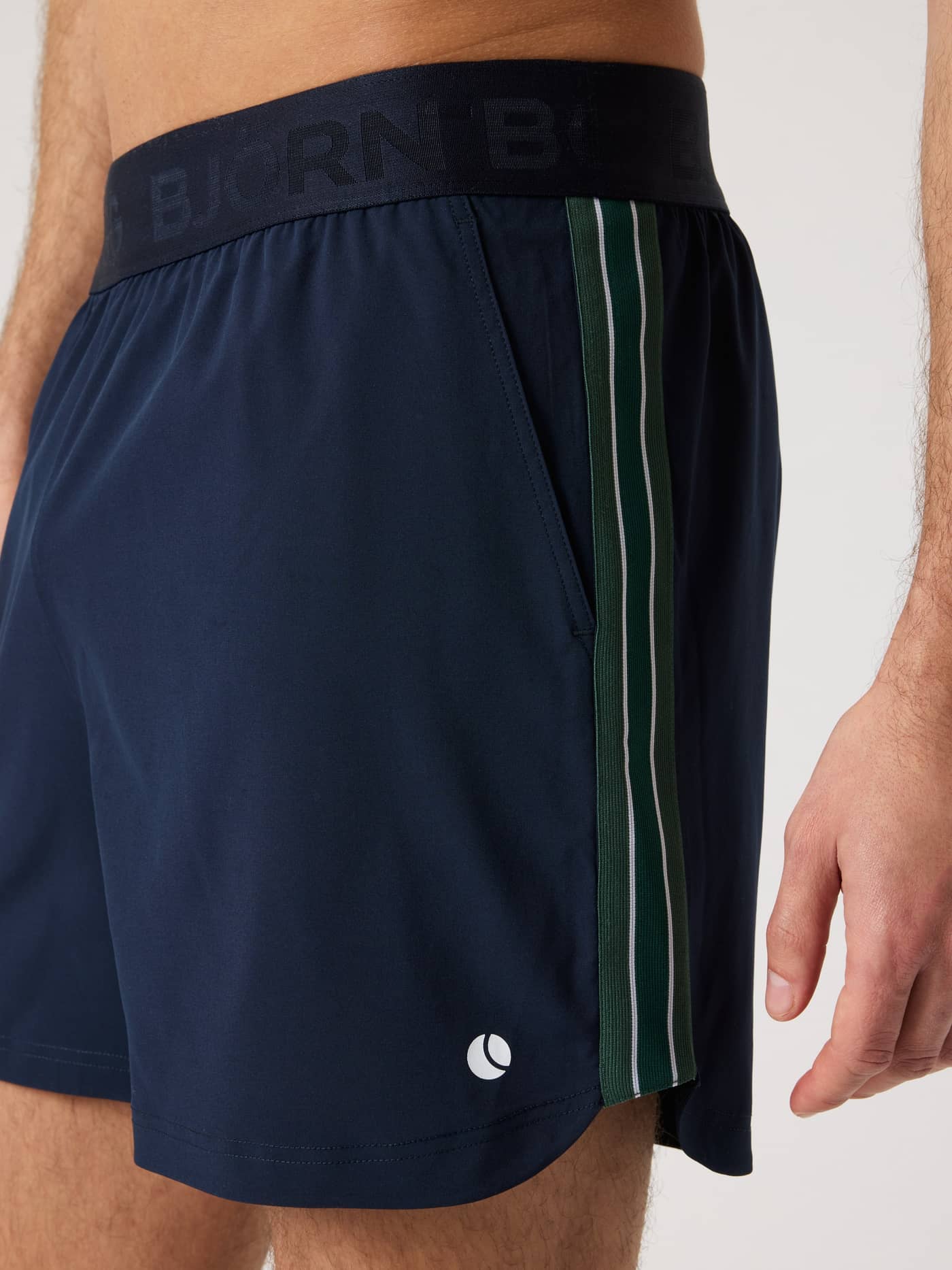 Side view of the Björn Borg Ace Retro Shorts 6 Inch in Night Sky (Navy) for men, with white tennis logo and side stripes. - Image 3