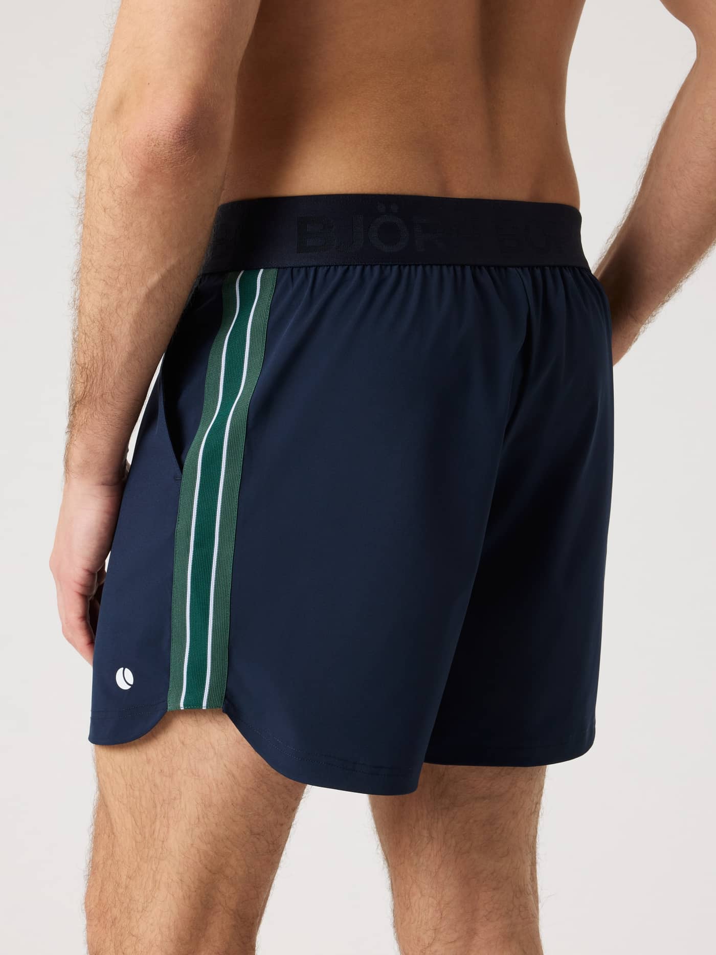Side view of the Ace Retro Shorts 6 Inch in Night sky (Navy) with retro stripes and a white tennis ball logo for tennis. - Image 2