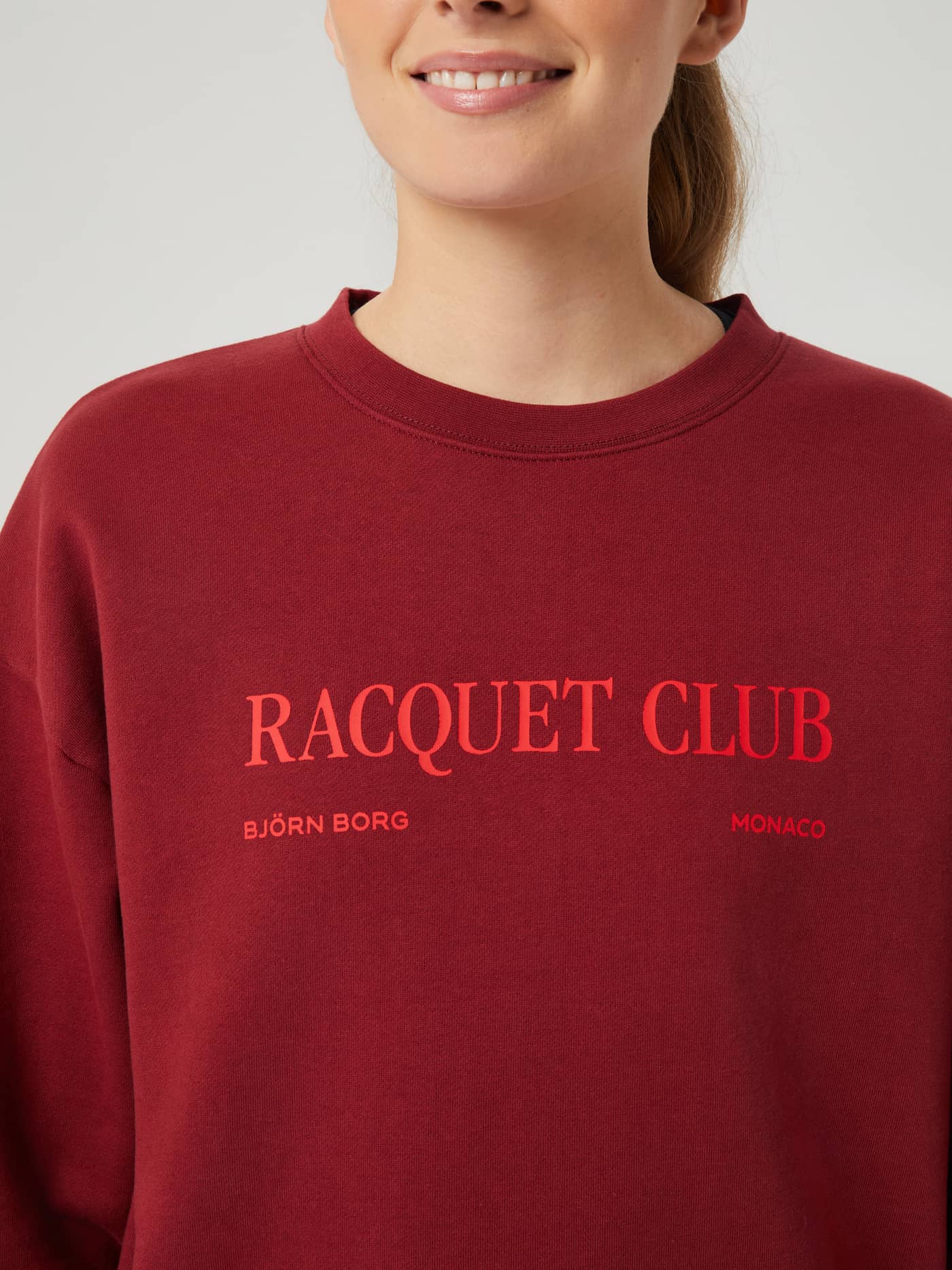 Detailed view of the women's Borg Boyfriend Crew in Pomegranate (Red), featuring a red Racquet Club graphic print. - Image 4