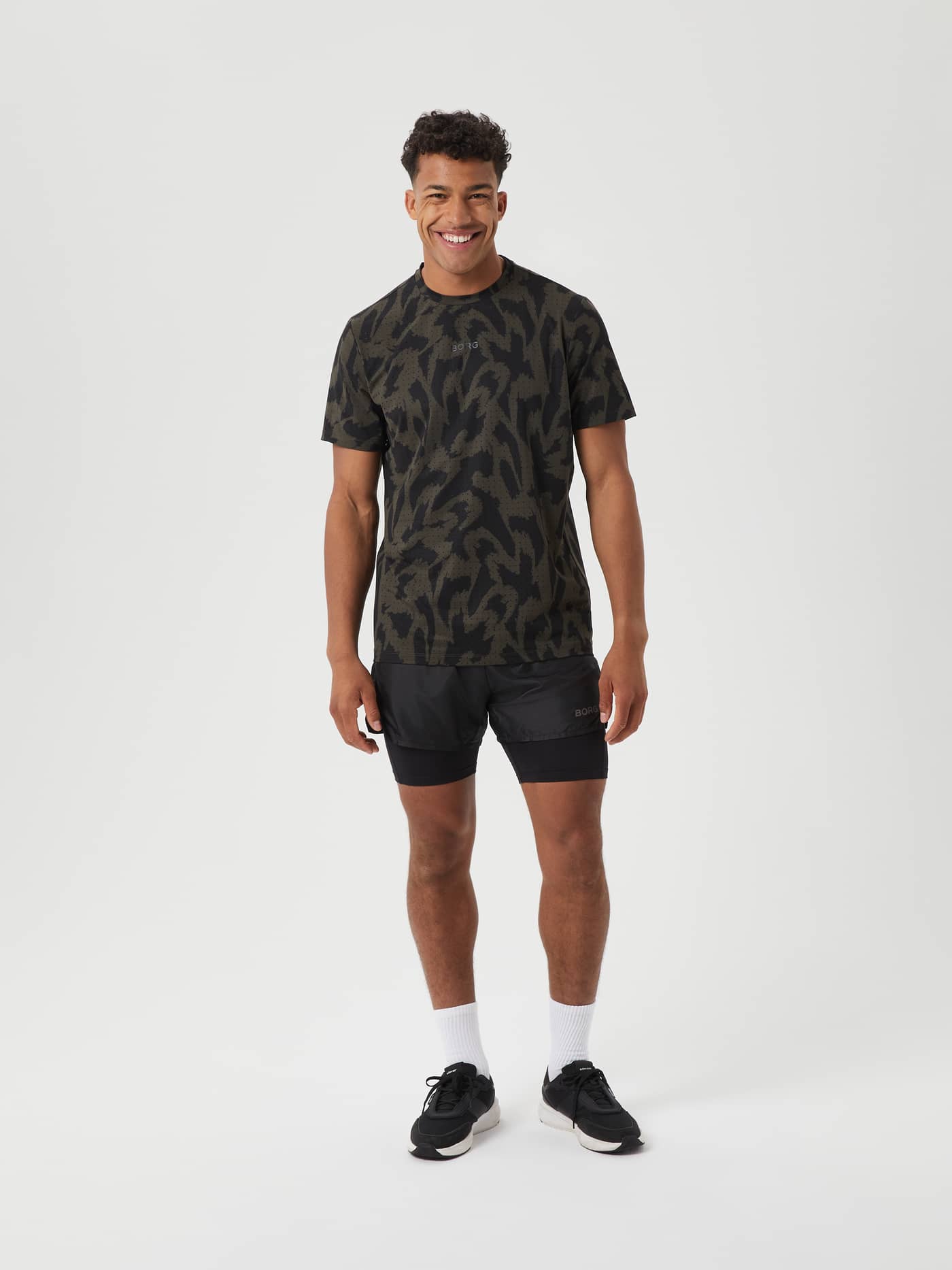 Full-body front view of a man in the olive and black Borg Running Perforated T-Shirt featuring a reflective logo. - Image 3