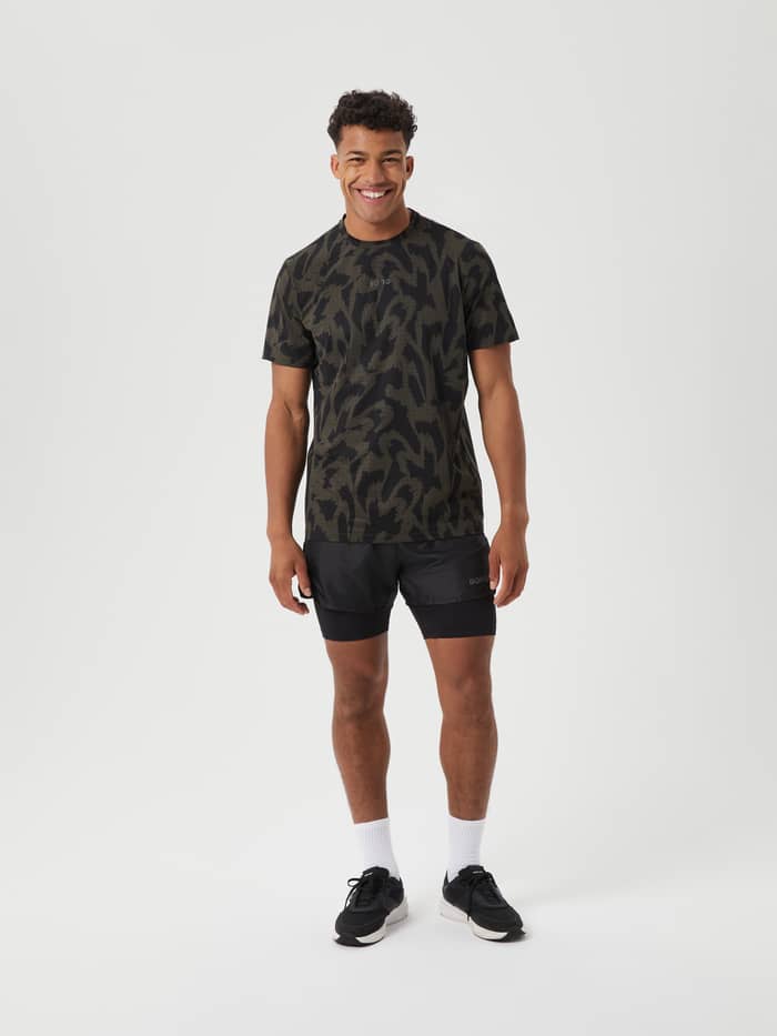 Volledig vooraanzicht van een man in het olijfgroene en zwarte Borg Running Perforated T-Shirt met reflecterend logo. - Image 3
