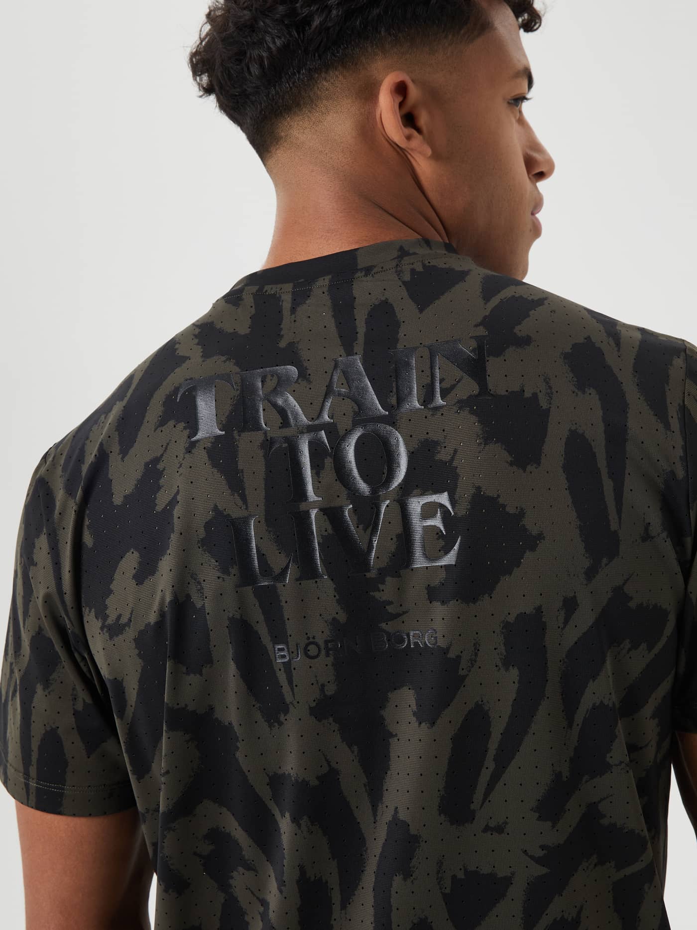 Back view of the Borg Running Perforated T-Shirt in green and black Running Aop with a reflective "TRAIN TO LIVE" print. - Image 4