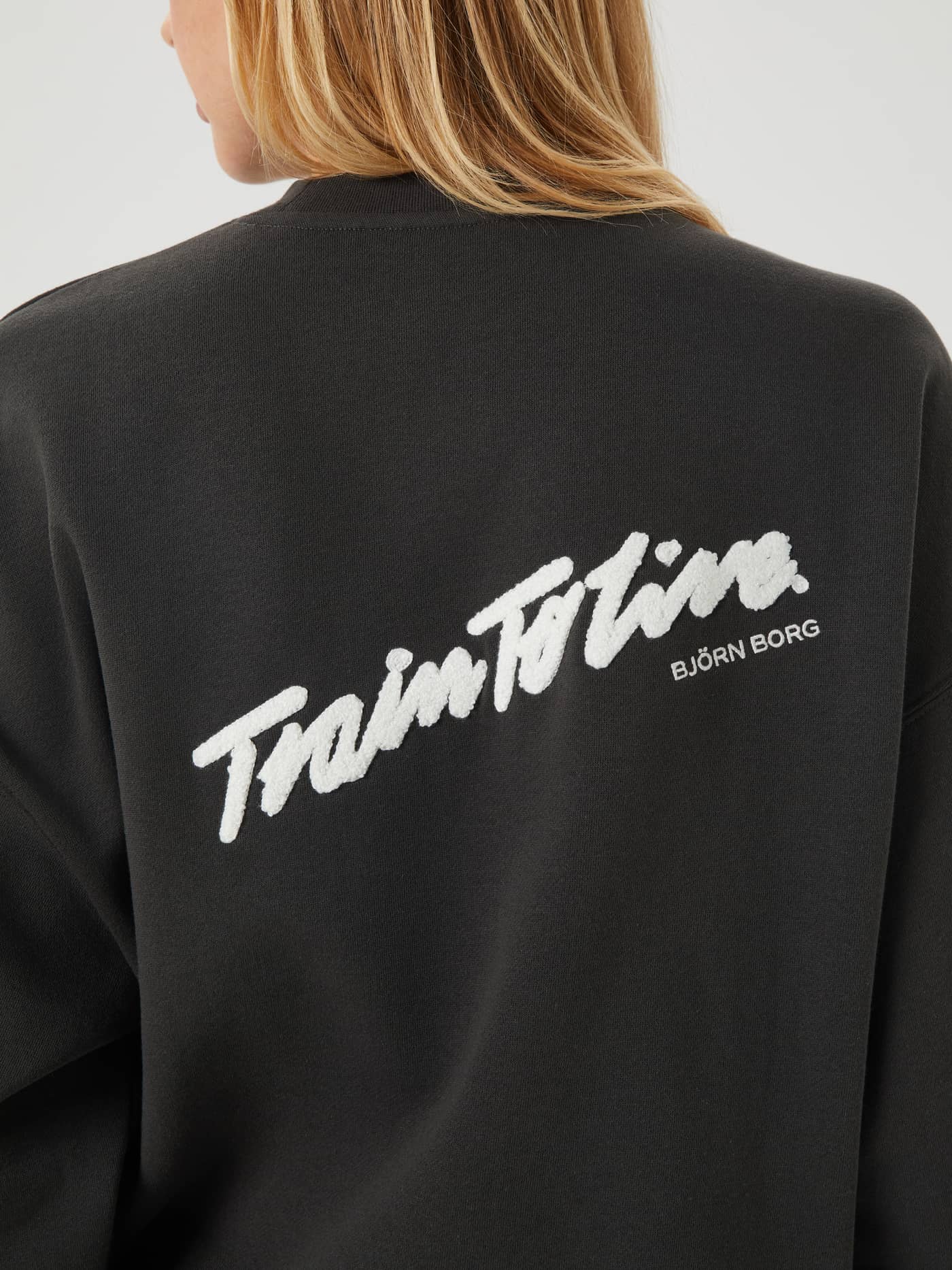 Close-up back view of the Studio Oversized Crew in Peat (Green) showcasing the large white training graphic print. - Image 4
