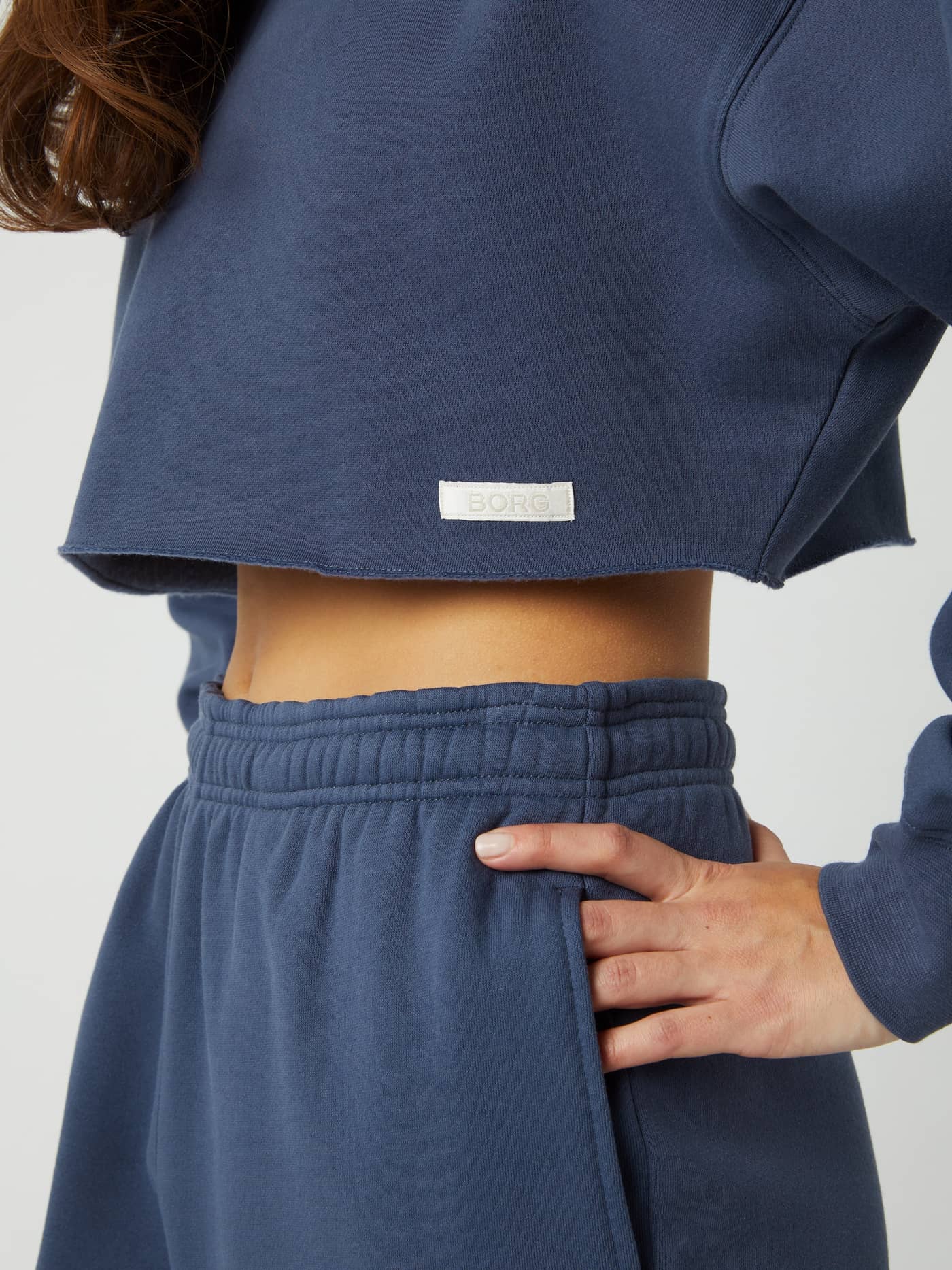 Vue latérale du Studio Oversized Cropped Crew en Nightshadow Blue (Bleu) avec coupe courte et étiquette BORG blanche. - Image 4
