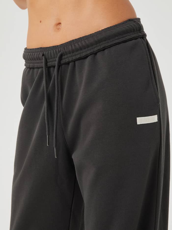 Close-up of the Studio Oversized Pants in Peat (Green) for training, highlighting the ribbed waistband and Borg logo.