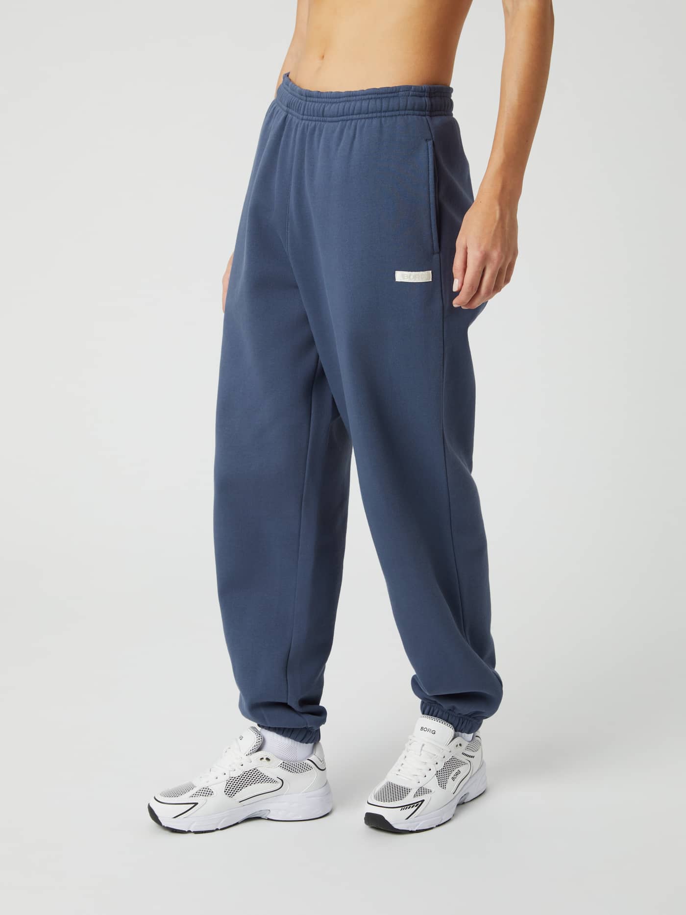 Side view of a model wearing the Björn Borg Studio Oversized Pants in Nightshadow Blue (Blue) in a soft cotton blend. - Image 2