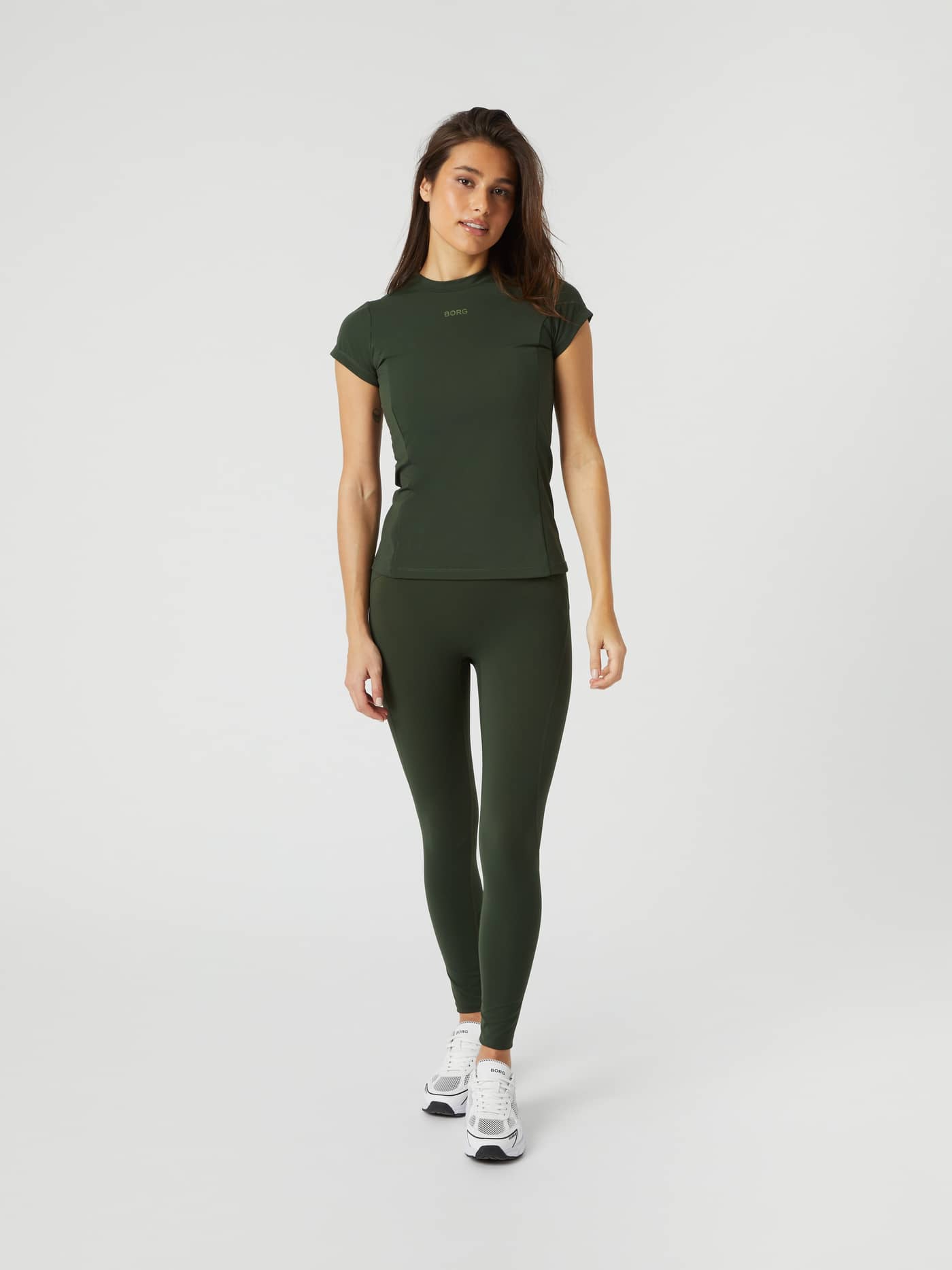 Front view of a female model wearing the Borg Sleek Tights in Duffel Bag green with a matching top. - Image 1