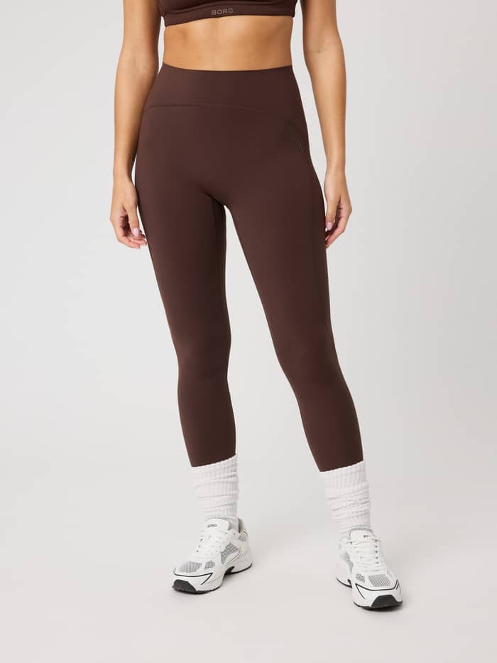 Vooraanzicht van de Borg Sleek Tights in Coffee Bean (Bruin) met een hoge taille, slim fit en bruin logo voor training.