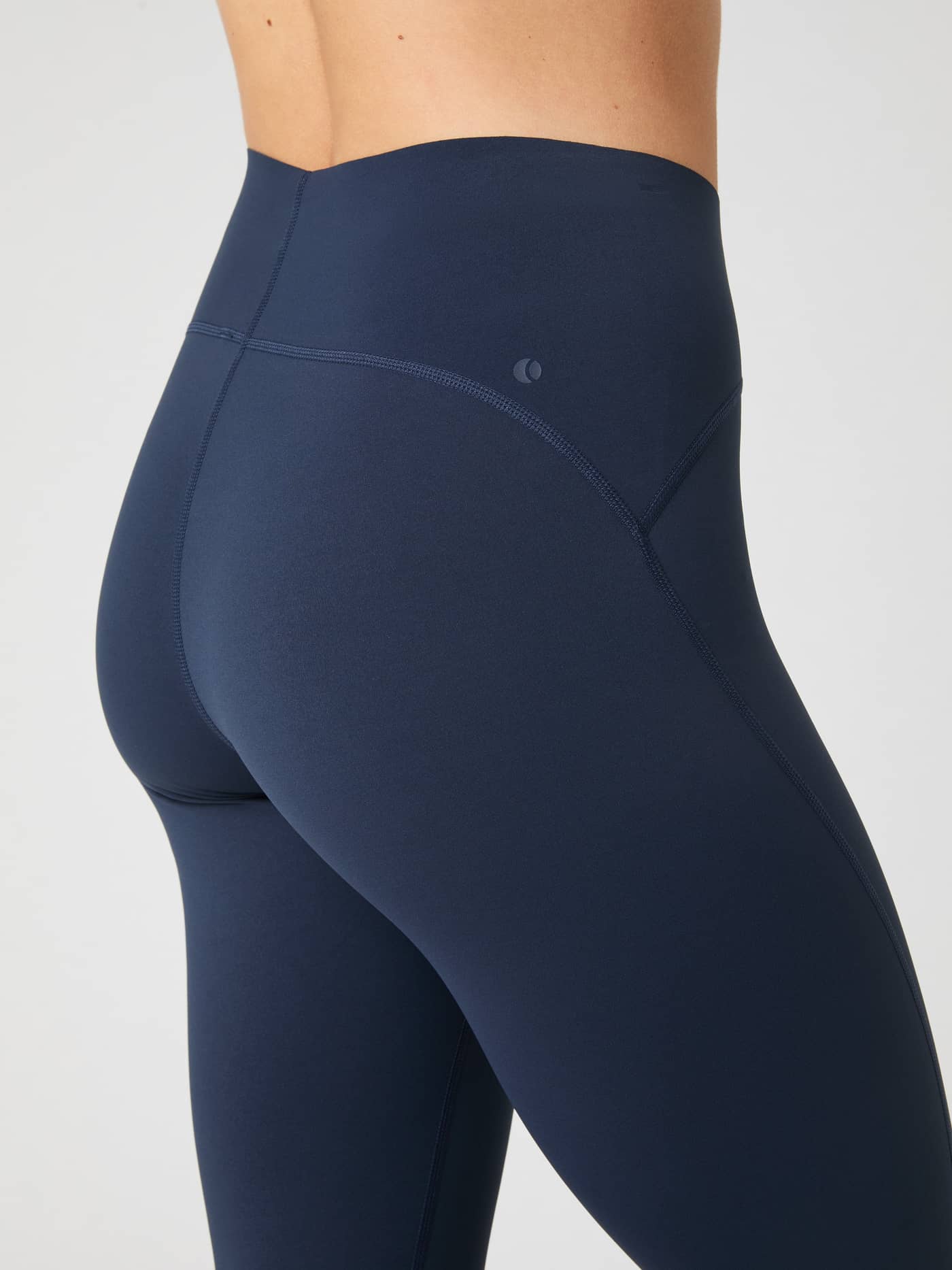 Close-up side view of a model's hip wearing the navy blue Borg Sleek Tights, showing the high waistband and seams. - Image 5