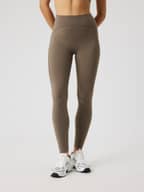 Front view of a model wearing the slim-fit, high-waisted Borg Sleek Tights in Falcon (Brown) for training.
