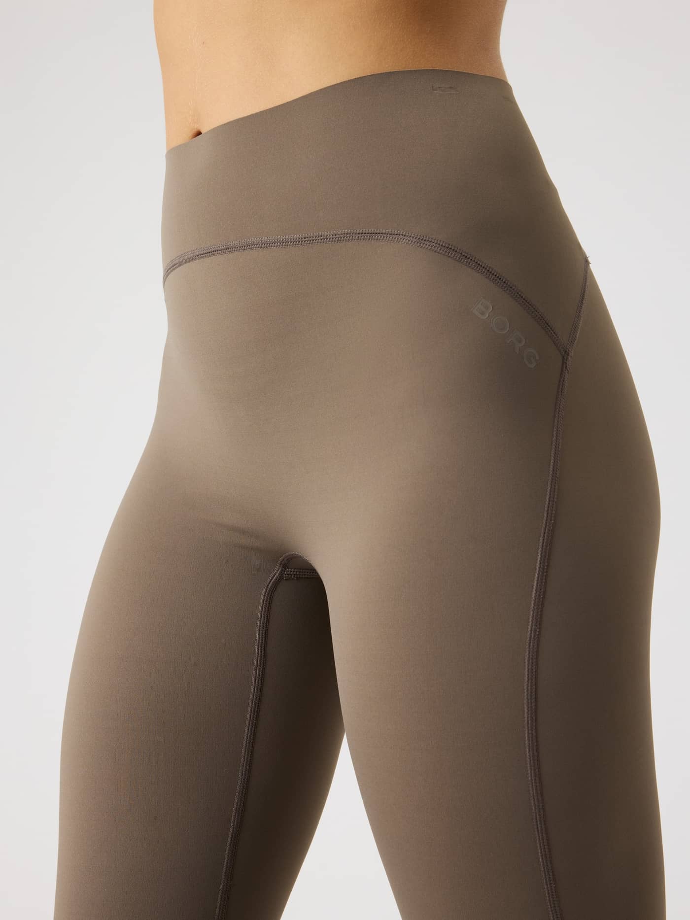 Close-up van de Borg Sleek Tights in Falcon (Bruin) met hoge taille, ton-sur-ton logo en slanke pasvorm voor training. - Image 5