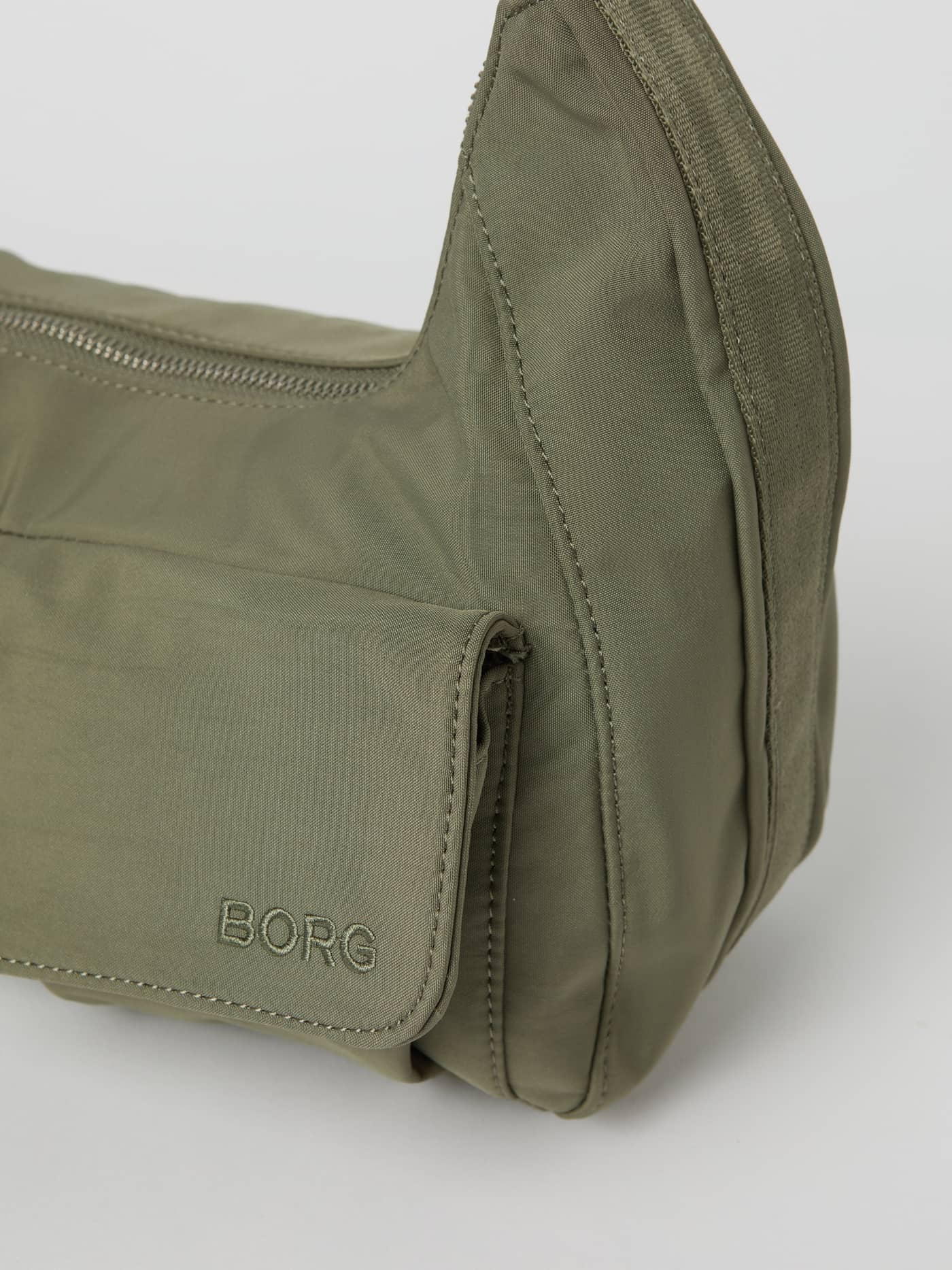Close-up van de Borg Cargo Shoulder Bag in Vetiver (Groen) met een cargovak en geborduurd logo in dezelfde kleur. - Image 3