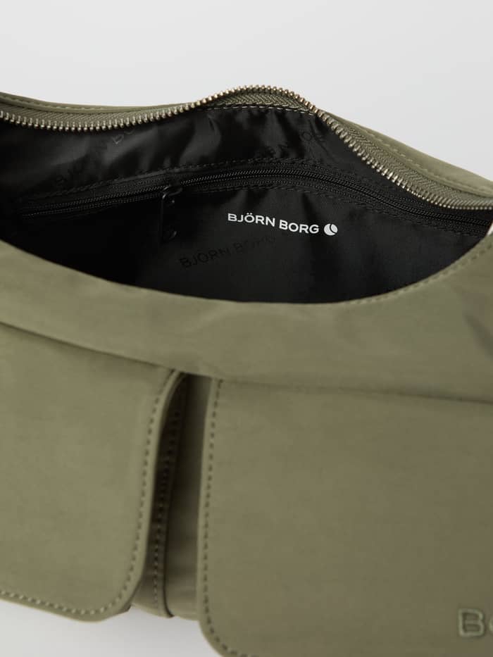 Close-up of the open Borg Cargo Shoulder Bag in Vetiver (Green) showing the white logo and black interior lining. - Image 4