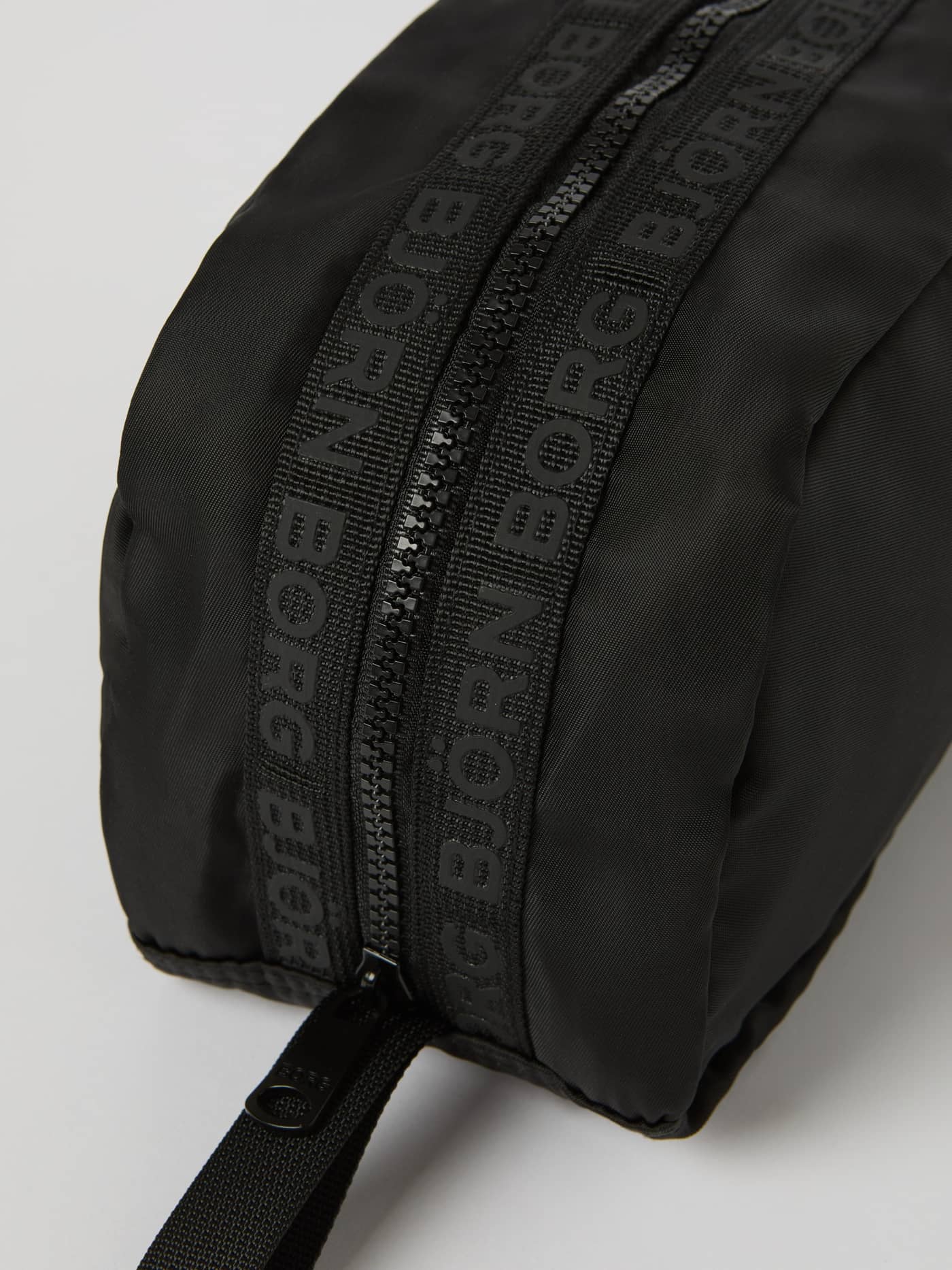 Close-up of the Borg Classic Toilet Case in Black Beauty (Black), featuring a black logo on the branded zipper tape. - Image 2