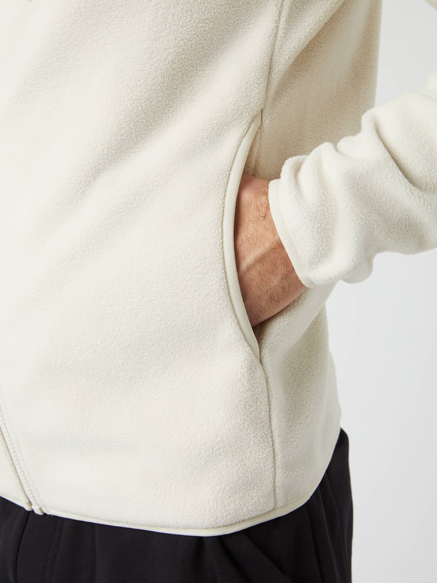 Close-up of a hand in the side pocket of the Borg Full Zip Fleece jacket in Silver Birch. - Image 2