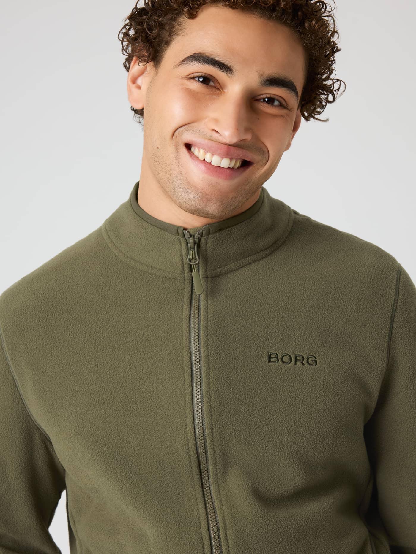 Close-up of the Borg Full Zip Fleece in Kalamata (Green) for training, featuring a tonal logo and soft microfleece. - Image 4