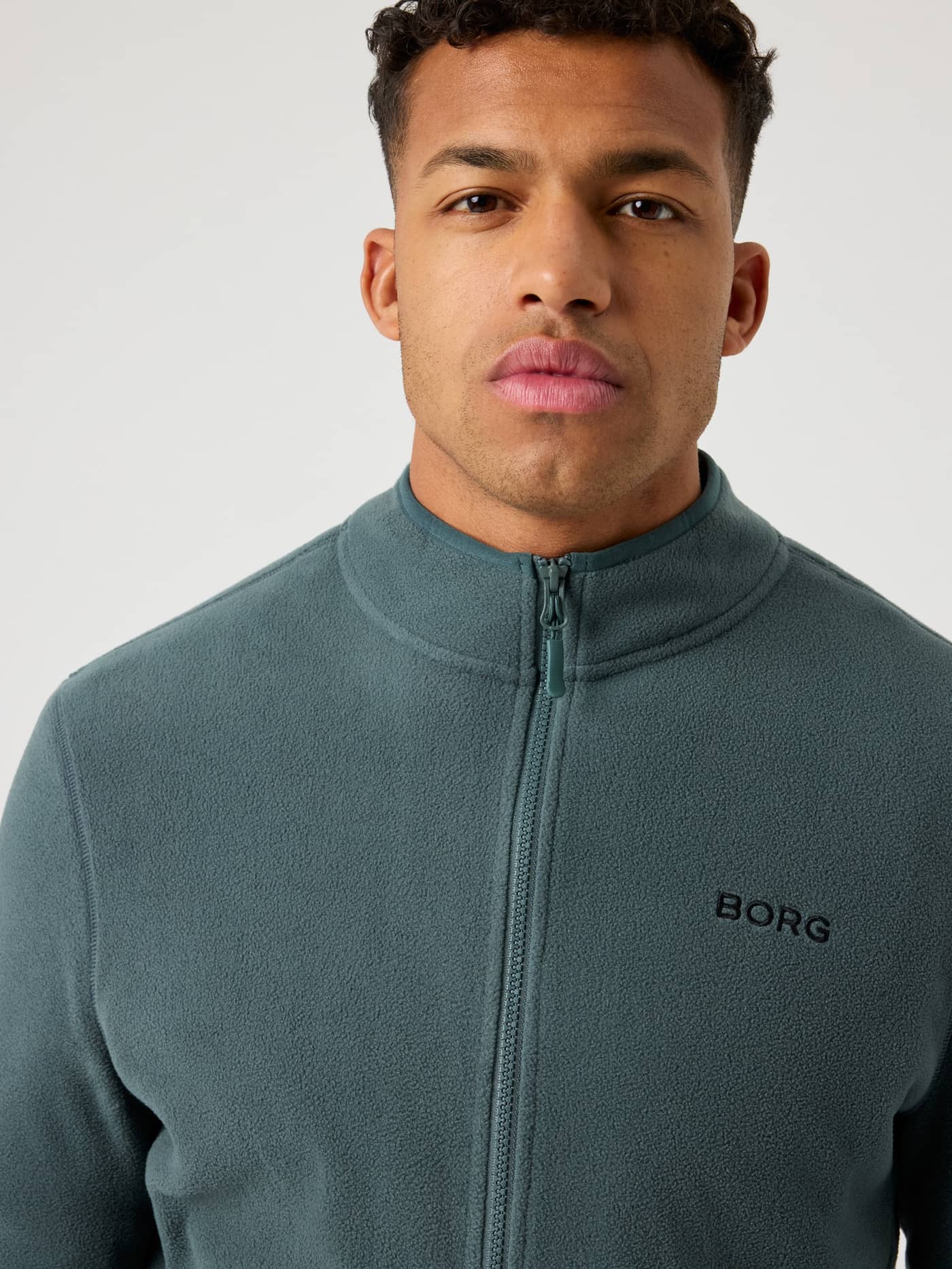 Närbild på mjuk Borg Full Zip Fleece i Urban Chic (Grön) med en svart logotyp på bröstet. - Image 4