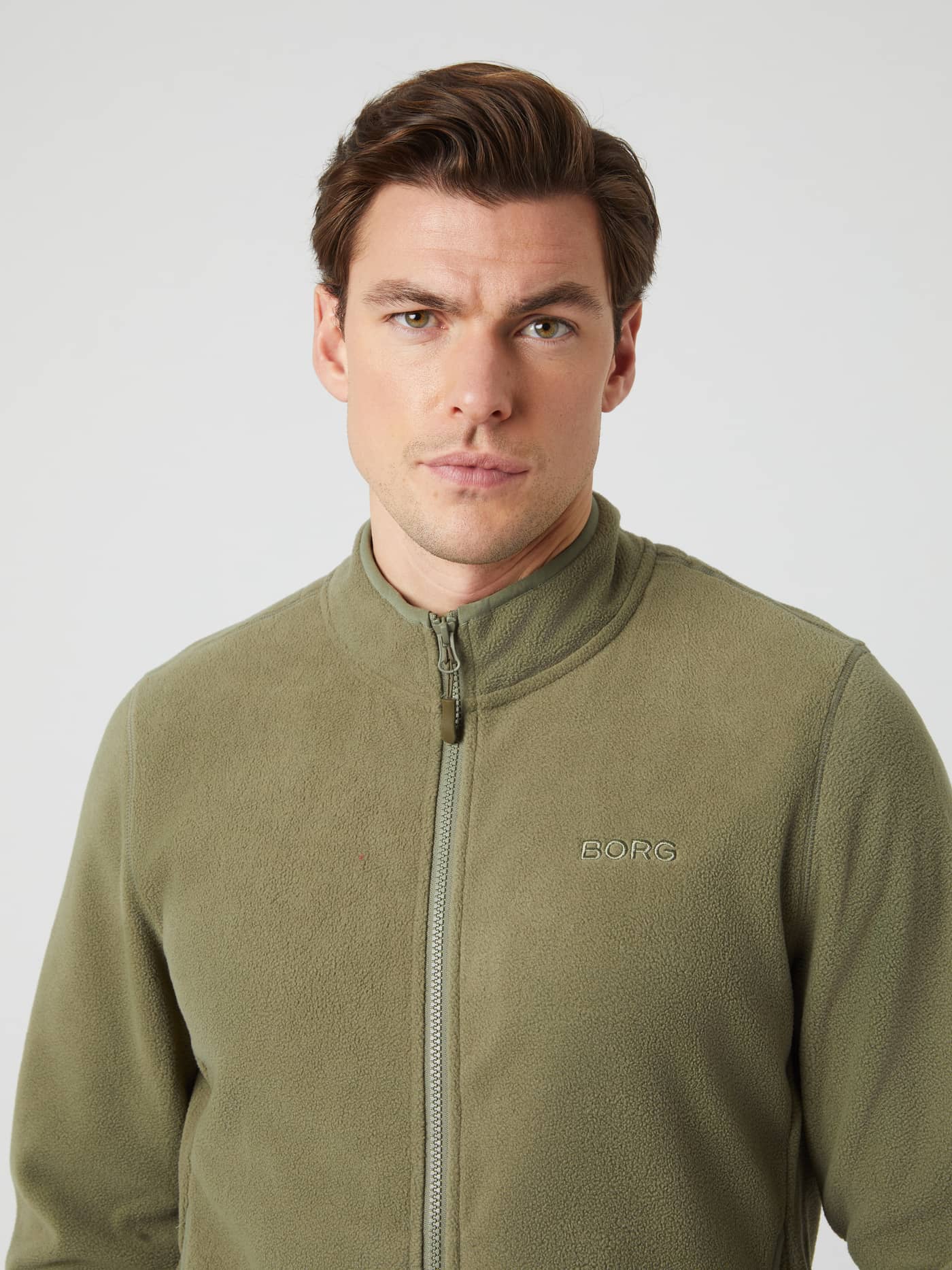 Close-up front view of a man wearing the Borg Full Zip Fleece in Deep Lichen Green. - Image 1