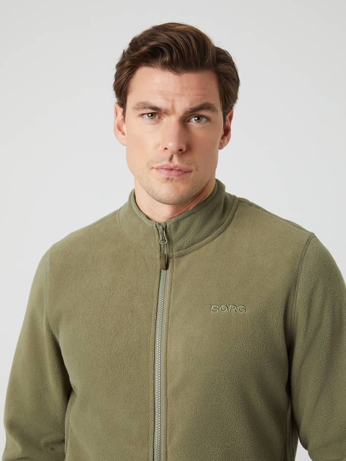 Close-up front view of a man wearing the Borg Full Zip Fleece in Deep Lichen Green.