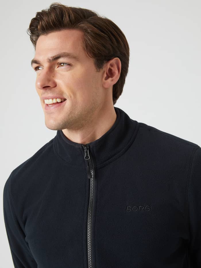 Close-up of a man wearing the black Borg Full Zip Fleece, showing the high collar and tonal BORG logo on the chest. - Image 2