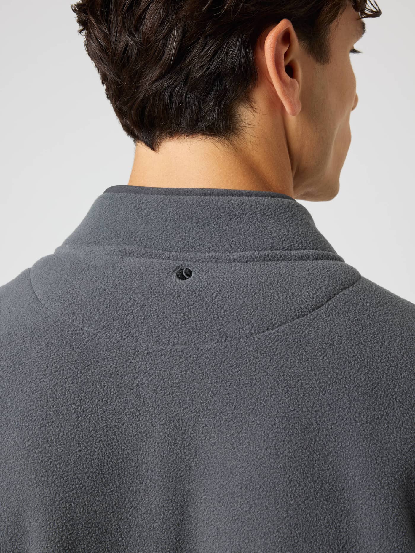 Detail view of the Borg Full Zip Fleece in Asphalt (Black) featuring tennis ball embroidery at the neck for training. - Image 5