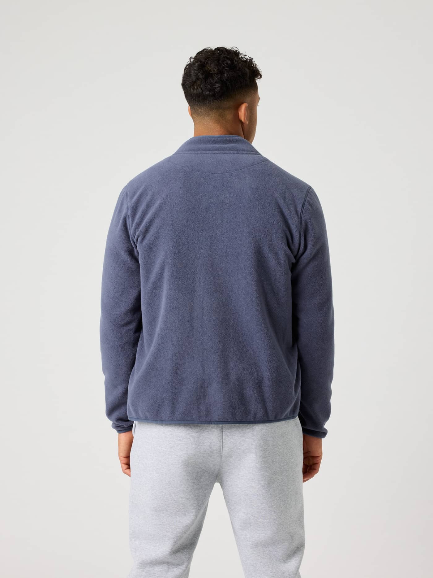 Achteraanzicht van een man in de Borg Full Zip Fleece in Odyssey Gray (Blauw), gemaakt van zacht en functioneel materiaal. - Image 2