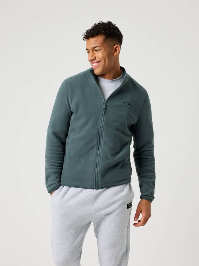 Stilren och funktionell Borg Full Zip Fleece i Urban Chic (Grön) på en man framifrån med en svart logotyp på bröstet.