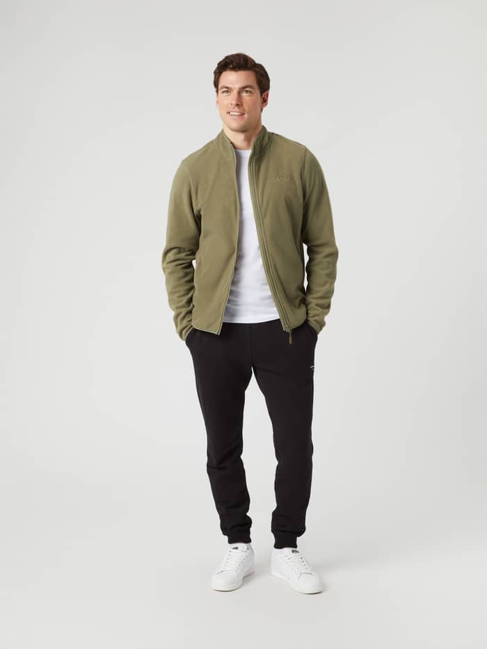Vooraanzicht van een man in de Borg Full Zip Fleece in Deep Lichen Green (Groen) met een wit T-shirt en zwarte joggers. - Image 3