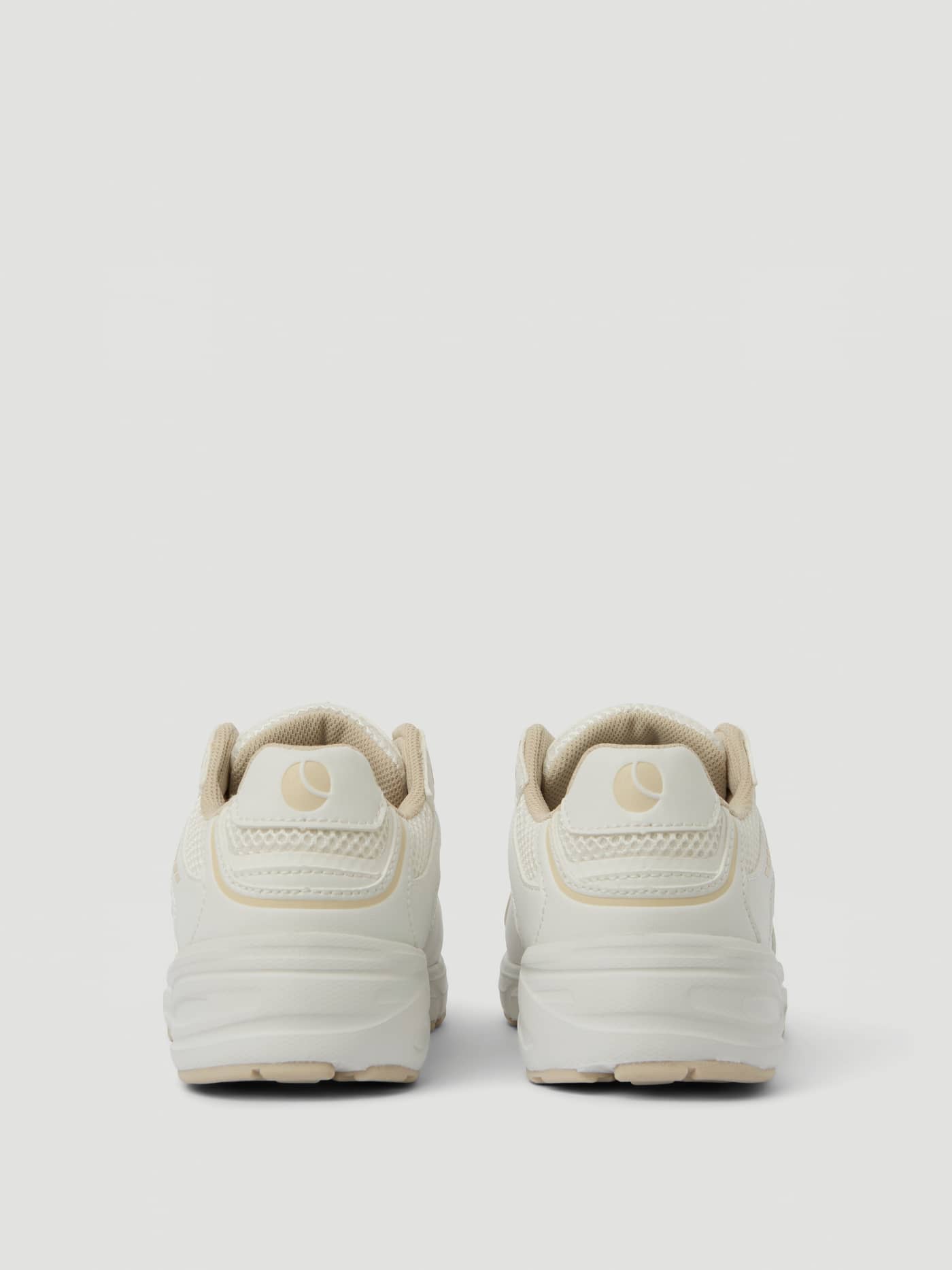 Back view of the beige Women's Grand Sneakers for training, featuring breathable mesh and a beige heel logo. - Image 3