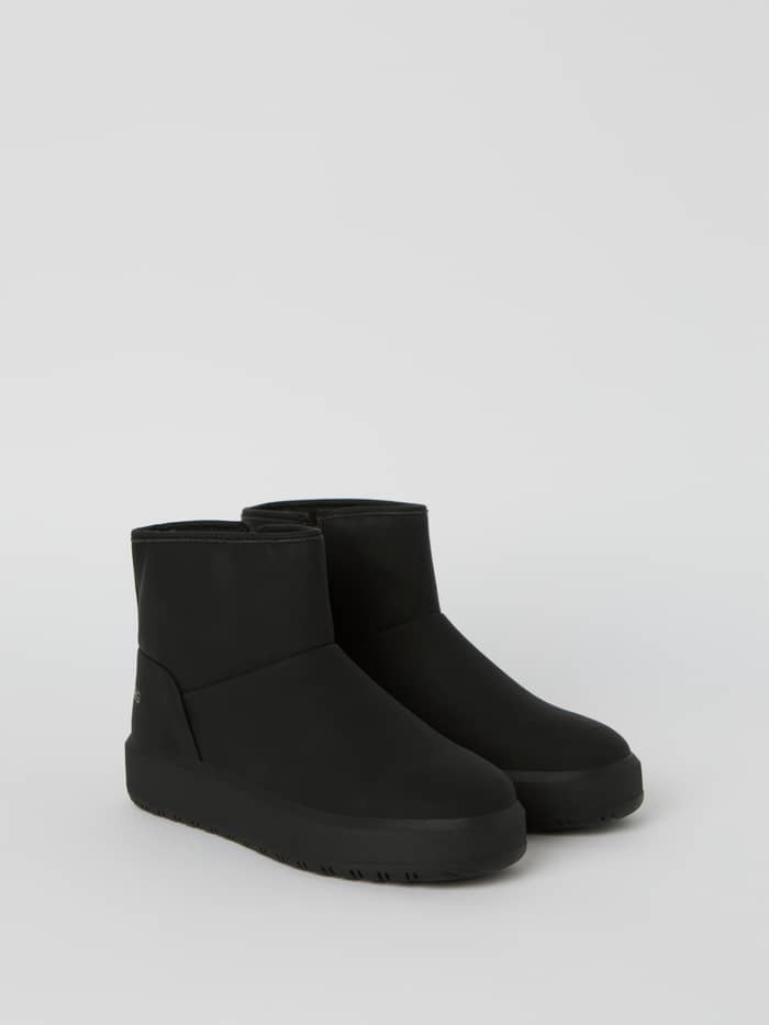 Women's Wooly Boots med overdel i sort syntetisk læder og høj gummisål set fra siden for stil og greb. - Image 2