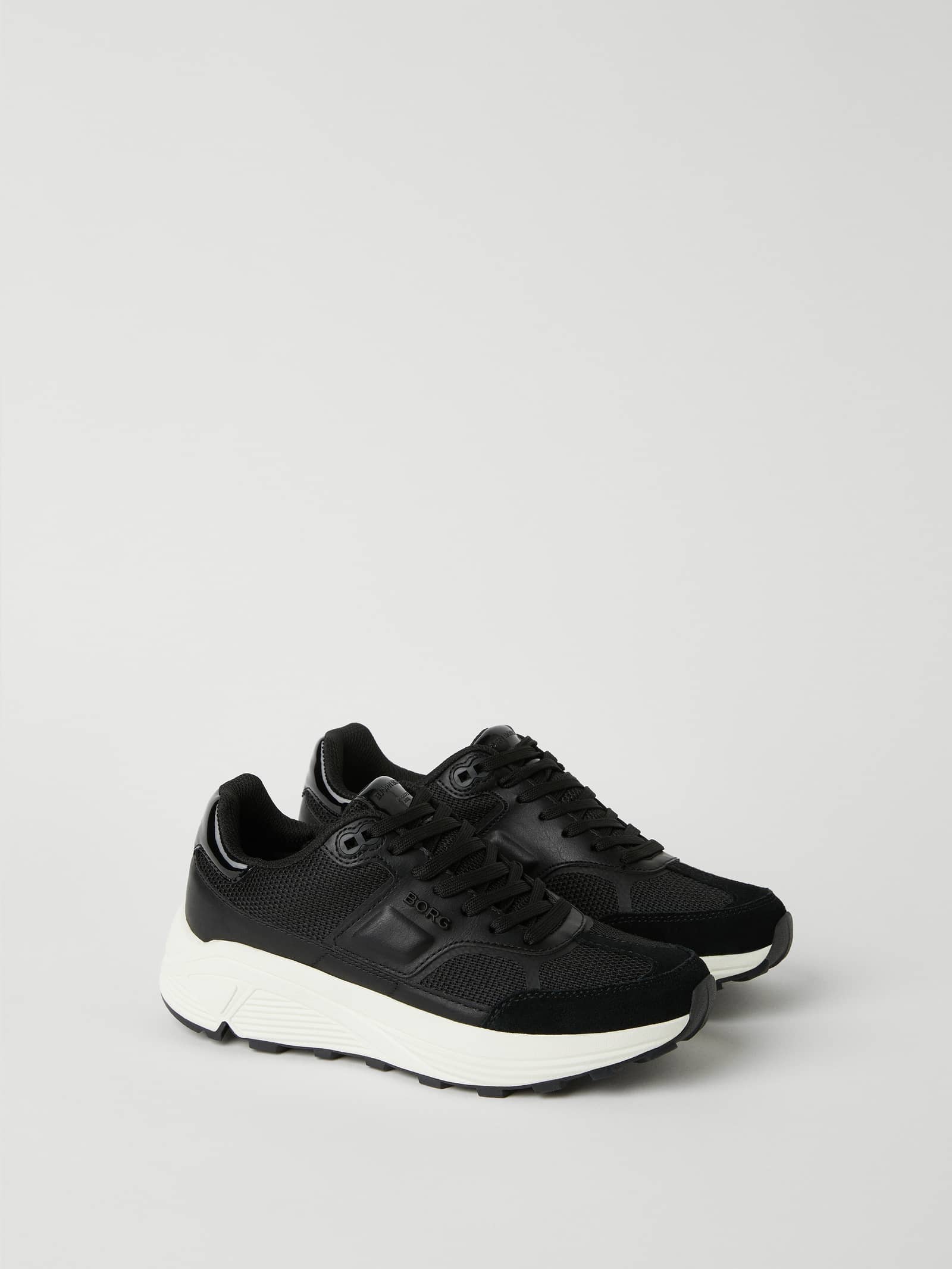 Vista lateral de las Women's R1300 Sneakers en negro con suela de goma gruesa y piel sintética para entrenamiento y estilo. - Image 1