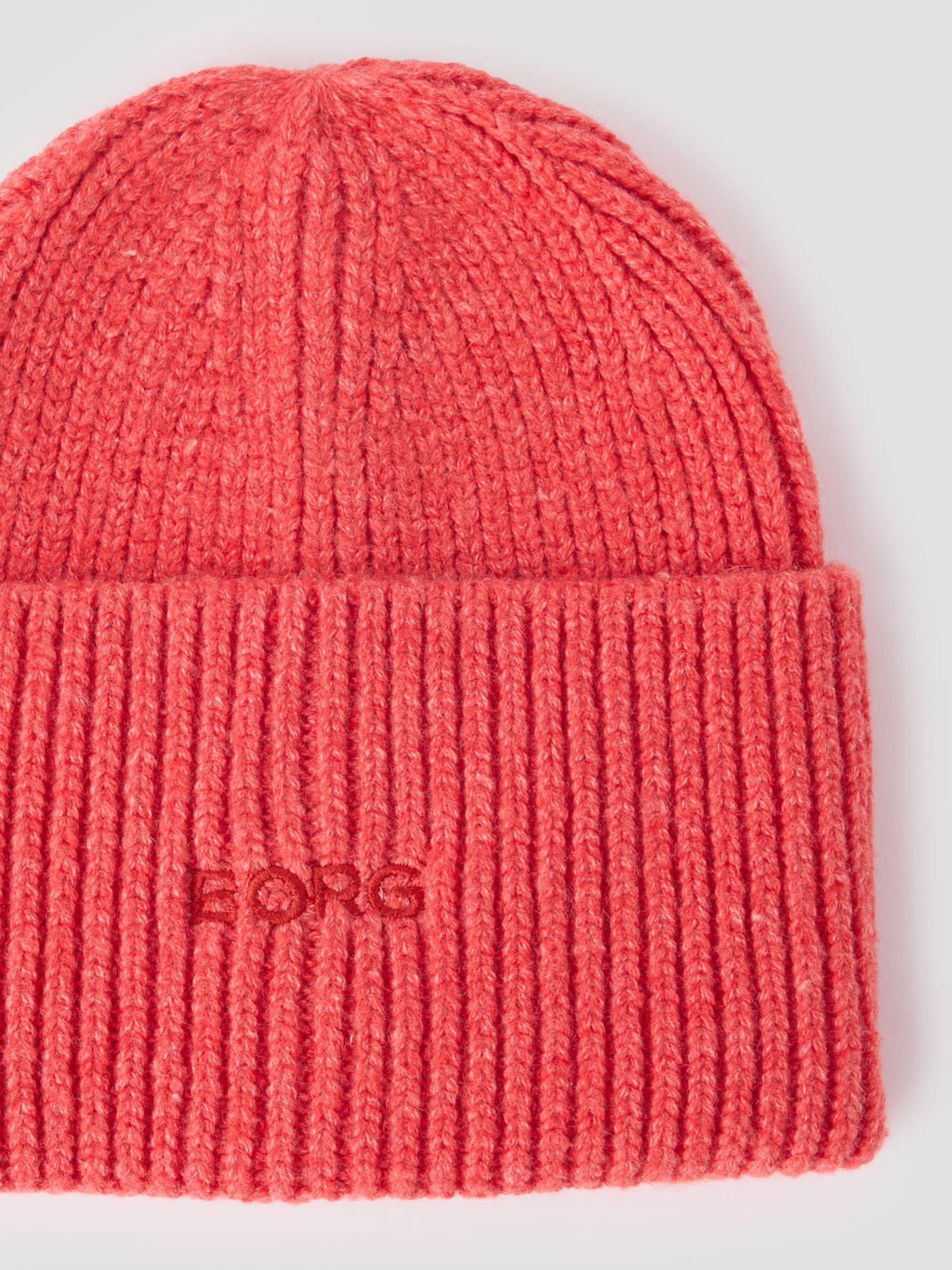 Close-up of the Studio Beanie in Flame Scarlet (Red) featuring a red embroidered Borg logo on a soft knitted cuff. - Image 3