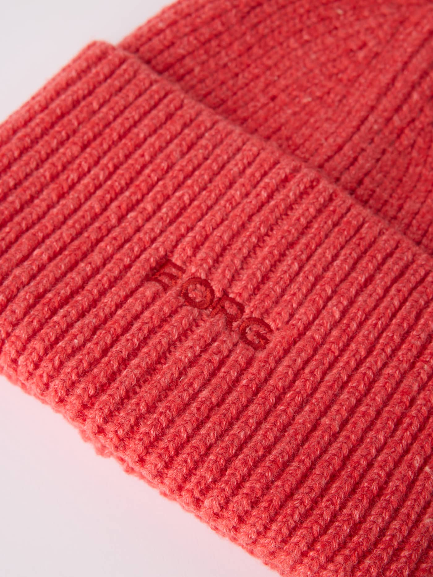 Close-up of the knitted Studio Beanie in Flame Scarlet (Red) with a tonal embroidered red Borg logo on the fold-up edge. - Image 2
