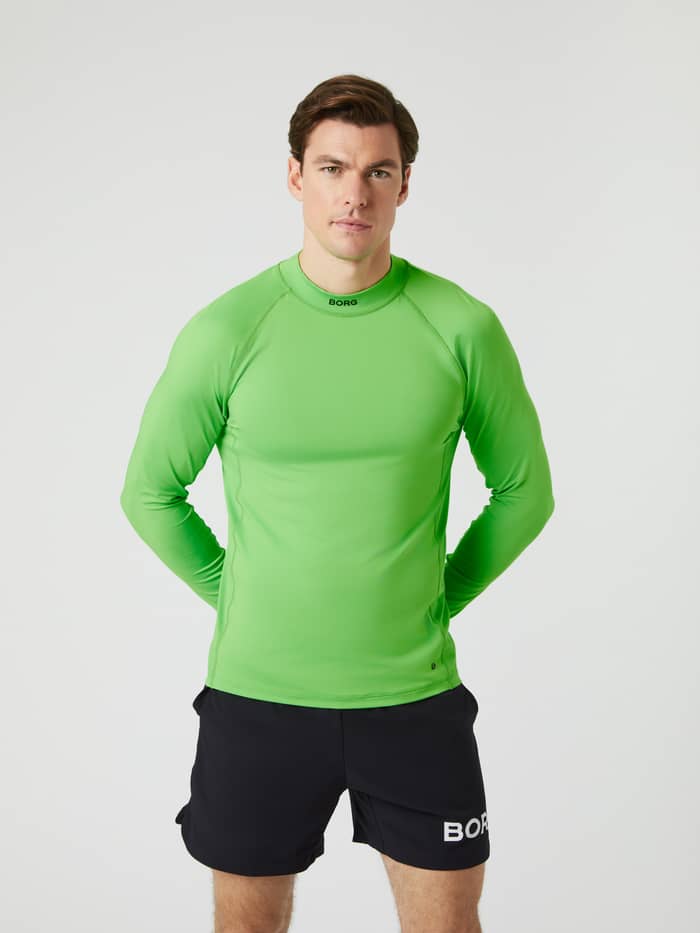 Front view of a man wearing the green Björn Borg Mock Neck Long Sleeve T-shirt with black shorts.