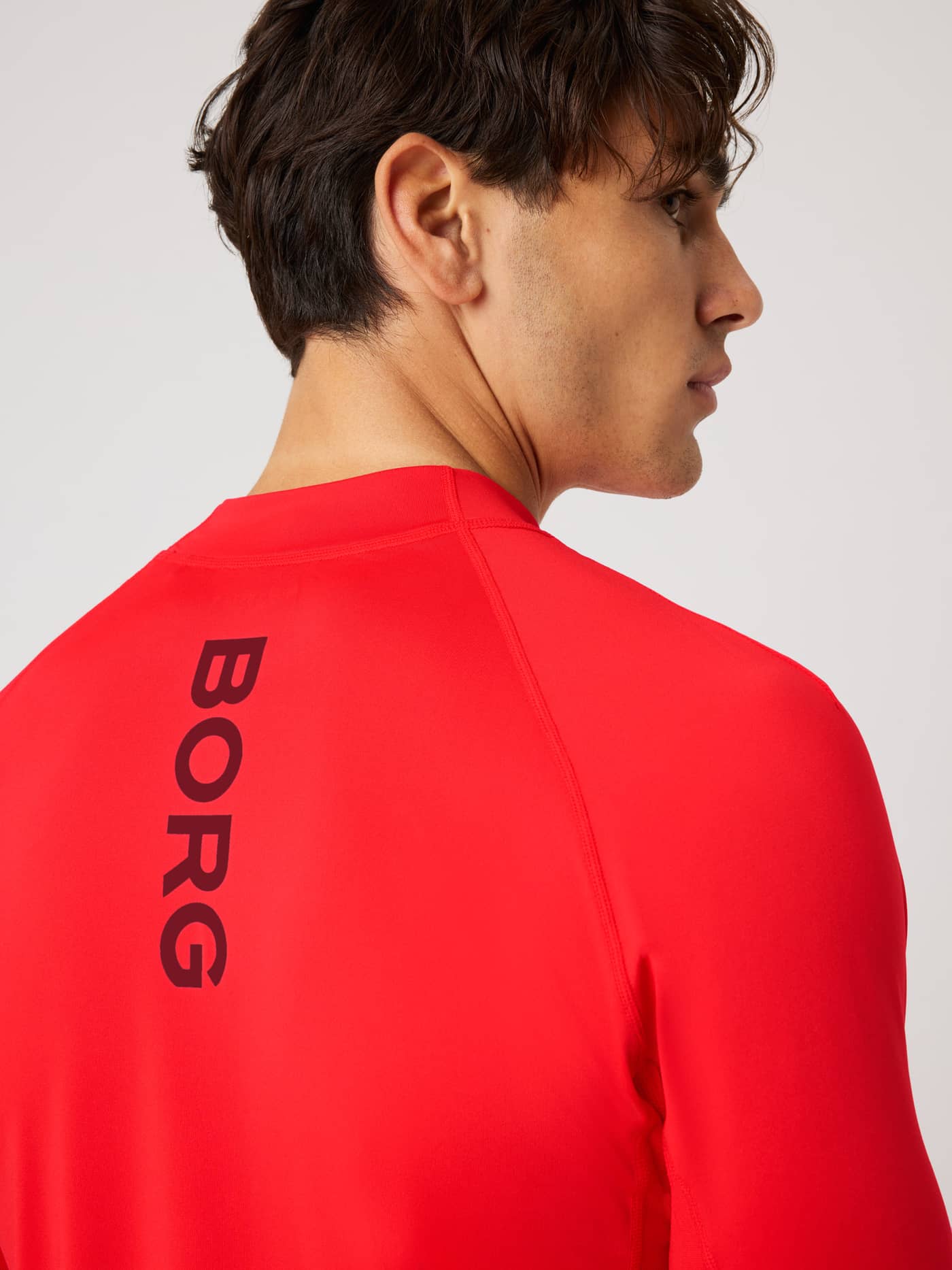 Back view of the Borg Mock Neck Ls T-Shirt in Flame Scarlet (Red) with a vertical black logo for training. - Image 4