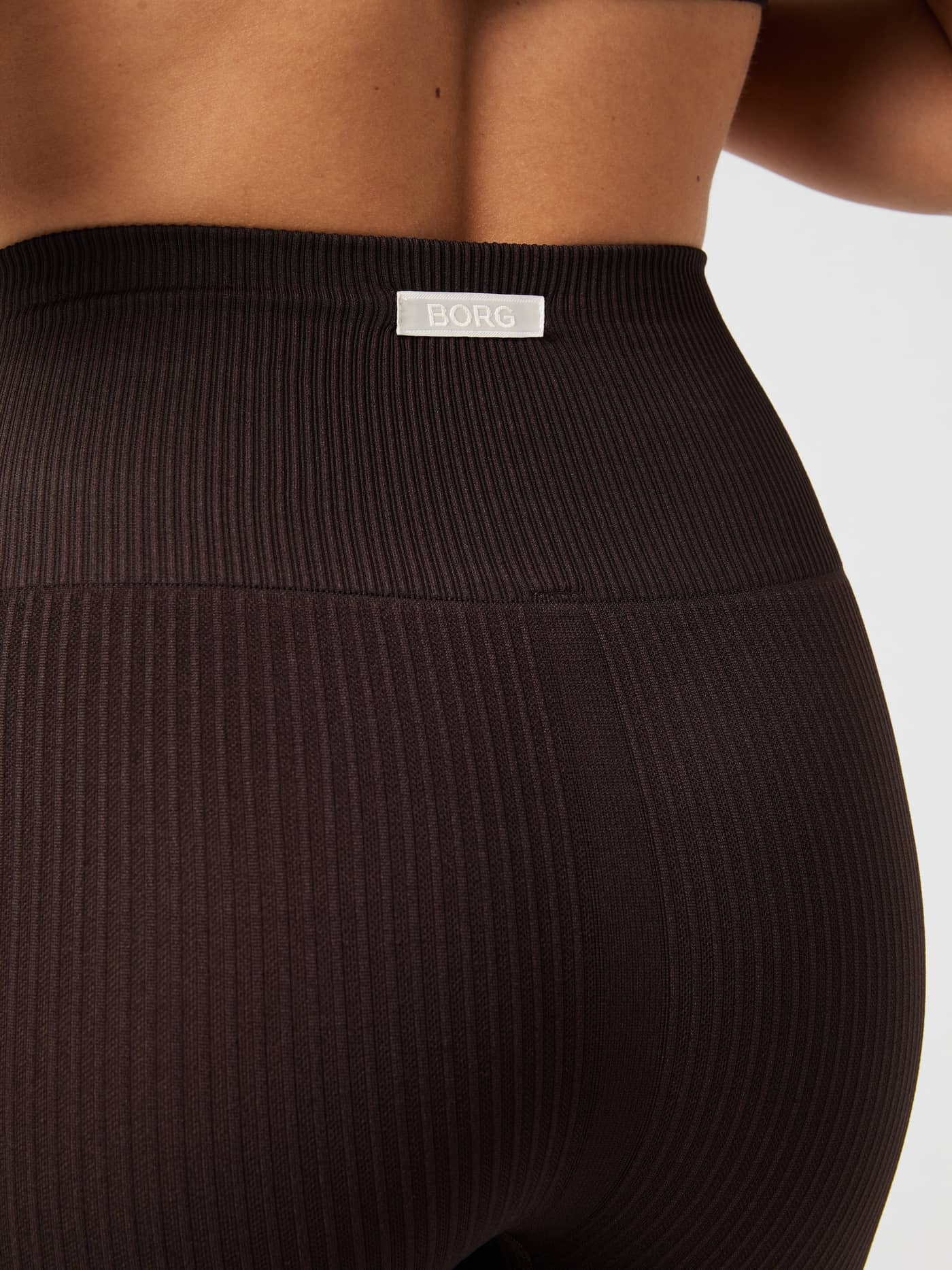 Studio Seamless Ribbed Tights in Molé (Bruin) met wit logo op de hoge tailleband voor training, achteraanzicht. - Image 2