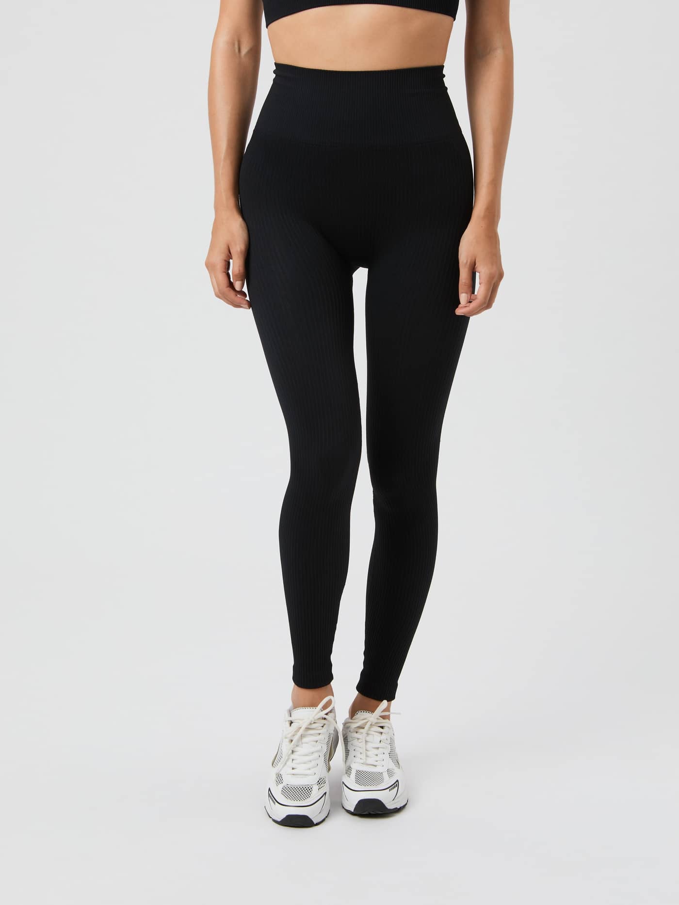 Front view of a model wearing the black high-waisted Björn Borg Studio Seamless Ribbed Tights. - Image 2