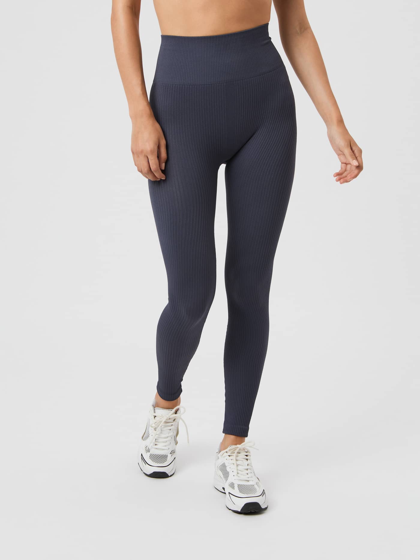 Front view of a model wearing the high-waisted Björn Borg Studio Seamless Ribbed Tights in Odyssey Gray. - Image 2