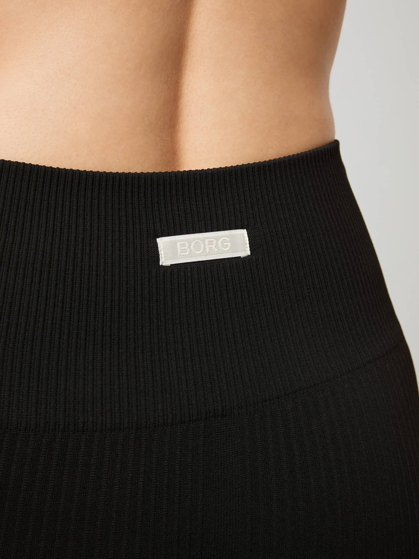 Close-up of the Björn Borg logo patch on the back waistband of the black Studio Seamless Ribbed Tights. - Image 4