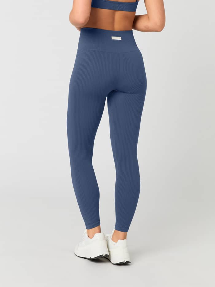 Back view of a woman wearing Björn Borg Studio Seamless Ribbed Tights in Nightshadow Blue.