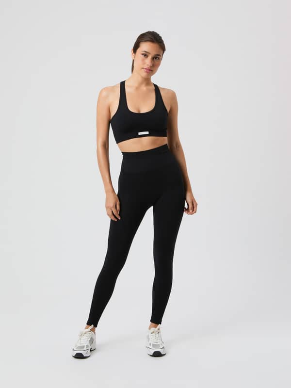 Studio Seamless Ribbed Tights i Black Beauty (Svart) för dam sedda framifrån med matchande sport-bh för träning.